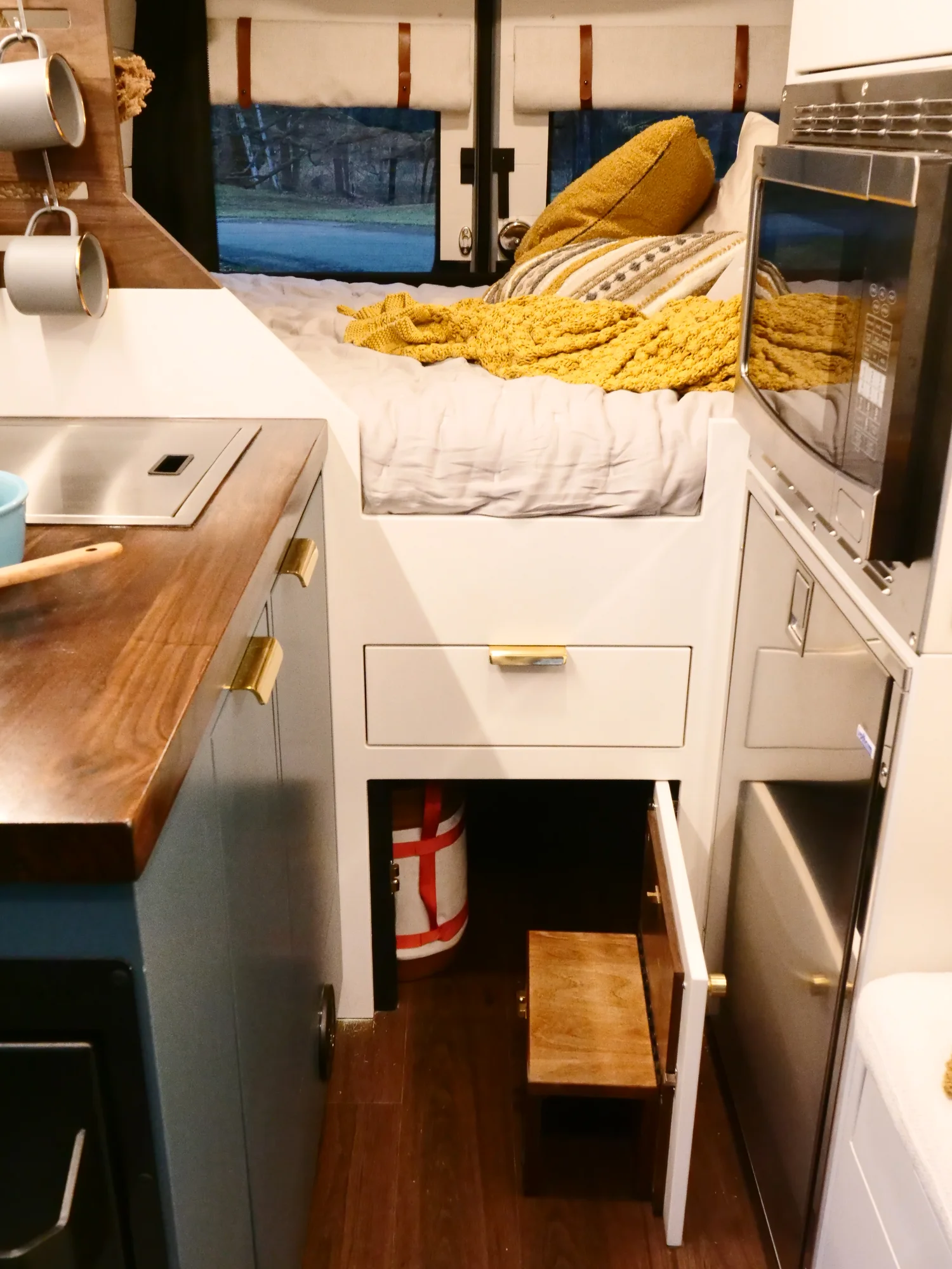 The Drifter 101 custom Ford Transit campervan built for Lynne by Drifter Vans, Drifter layout with a mid-century modern interior, dark walnut countertop, and gold hardware