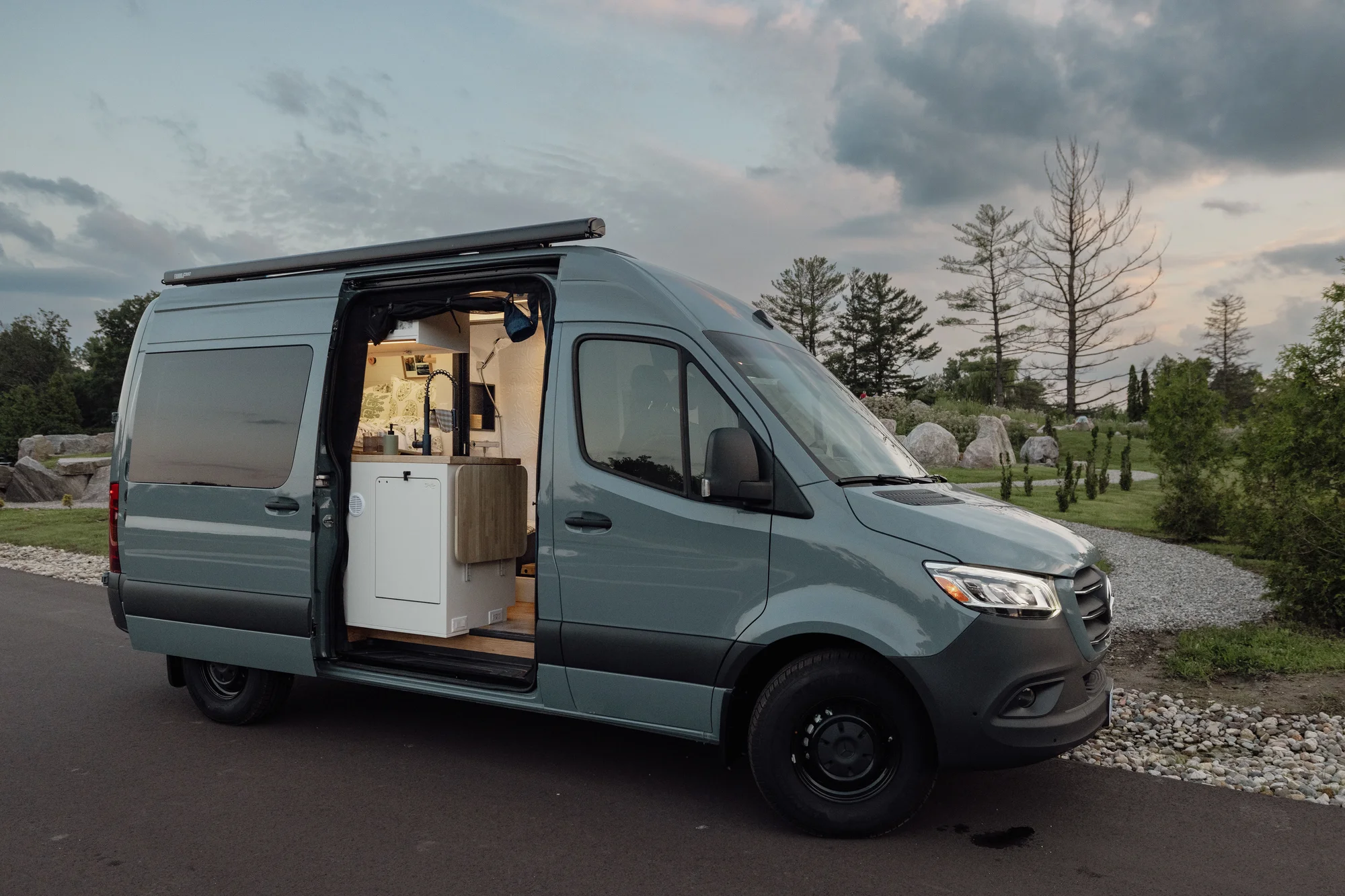 The Drifter 101 custom Mercedes-Benz Sprinter campervan built for Tanya by Drifter Vans, rustic interior with light blue cabinetry, butcher block countertop, and oil-rubbed bronze fixtures
