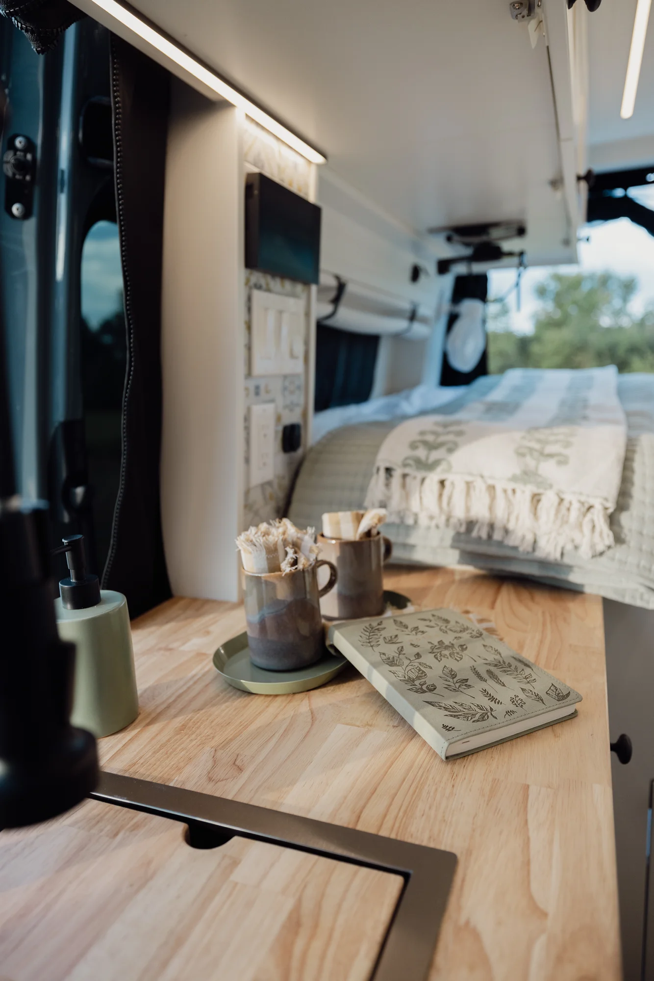 The Drifter 101 custom Mercedes-Benz Sprinter campervan built for Tanya by Drifter Vans, rustic interior with light blue cabinetry, butcher block countertop, and oil-rubbed bronze fixtures