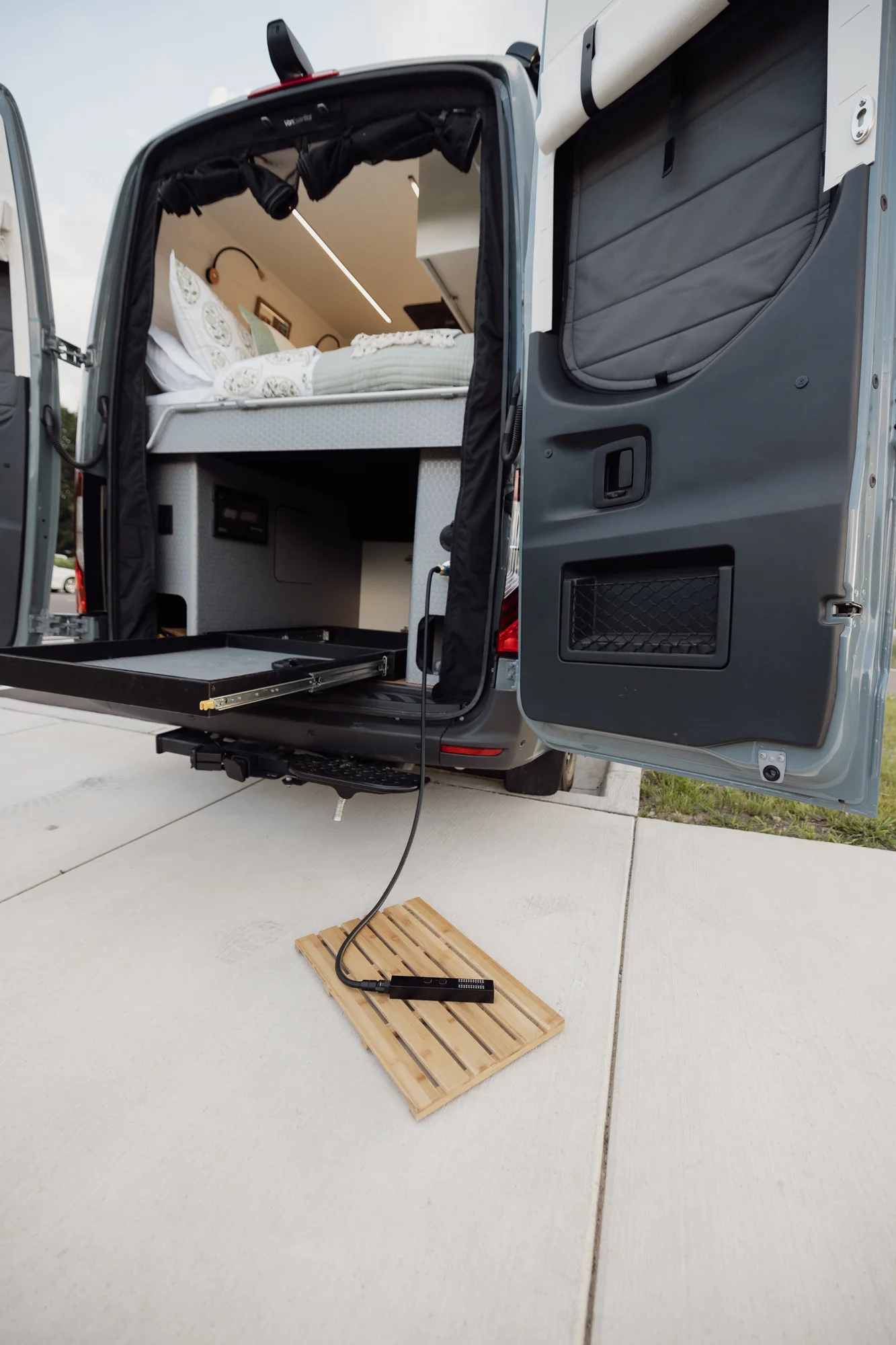 The Drifter 101 custom Mercedes-Benz Sprinter campervan built for Tanya by Drifter Vans, rustic interior with light blue cabinetry, butcher block countertop, and oil-rubbed bronze fixtures