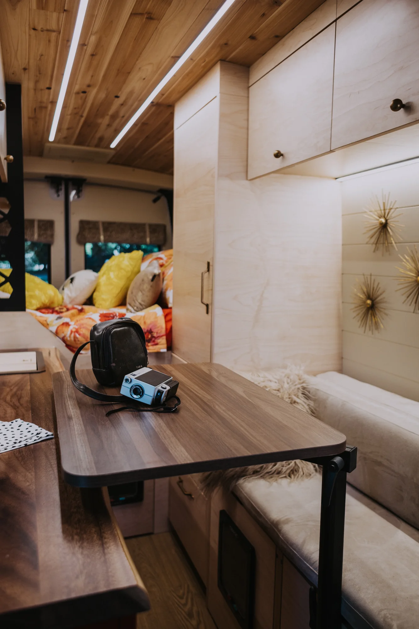 The Drifter 101 custom Ford Transit campervan built for Kim by Drifter Vans, Drifter layout with floral bedding, wood ceiling, and black shower fixtures