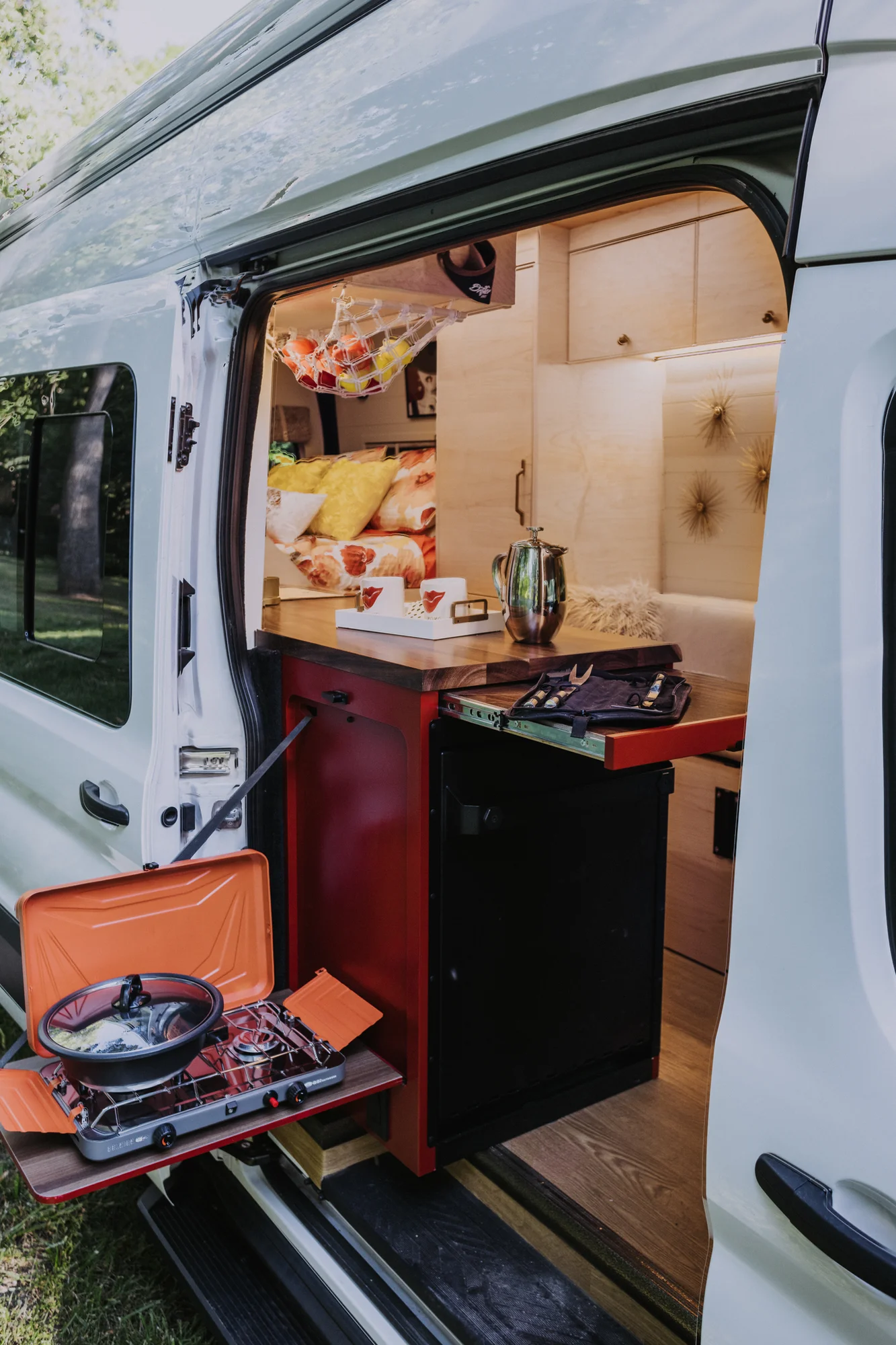 The Drifter 101 custom Ford Transit campervan built for Kim by Drifter Vans, Drifter layout with floral bedding, wood ceiling, and black shower fixtures