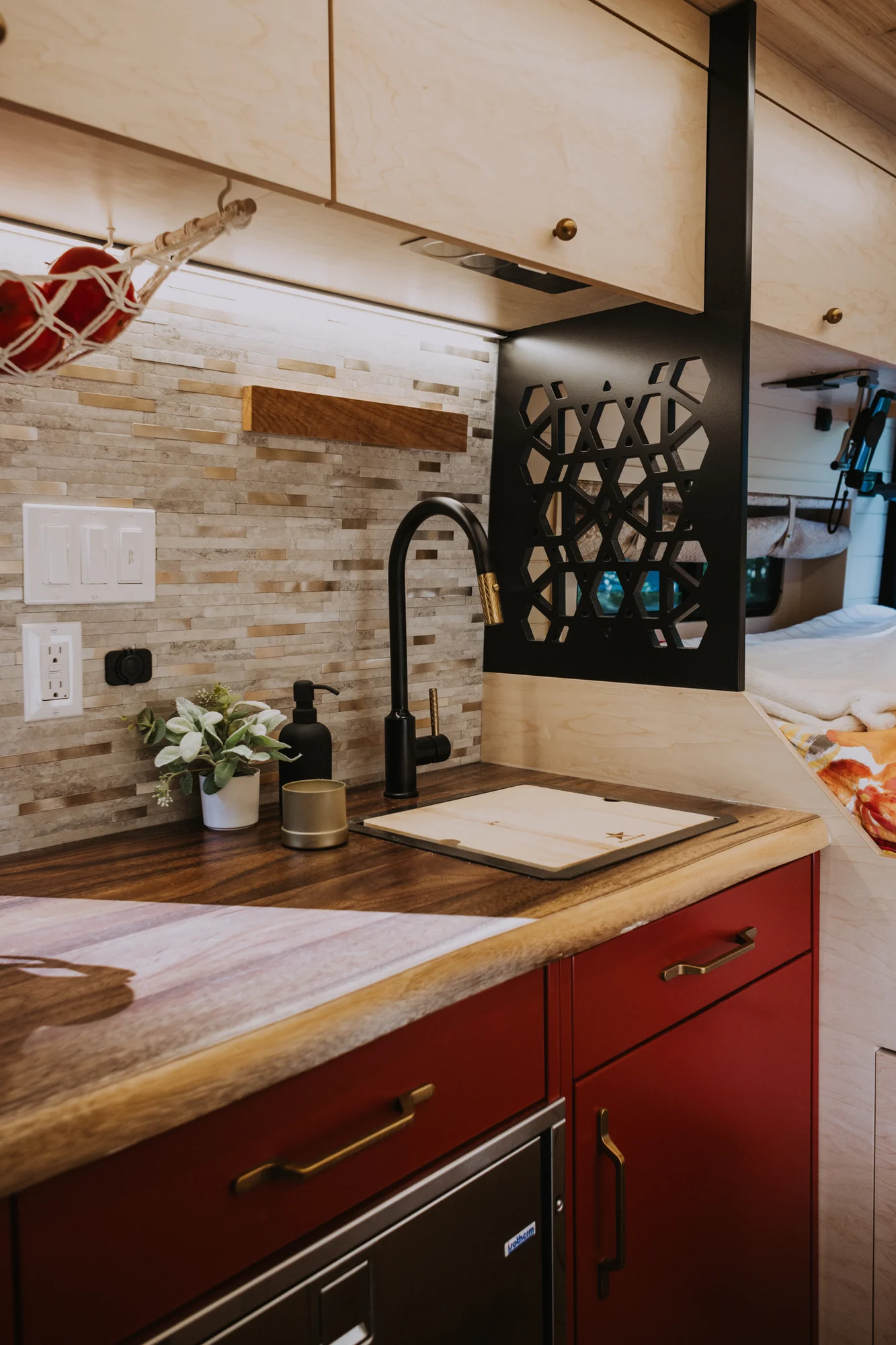 The Drifter 101 custom Ford Transit campervan built for Kim by Drifter Vans, Drifter layout with floral bedding, wood ceiling, and black shower fixtures