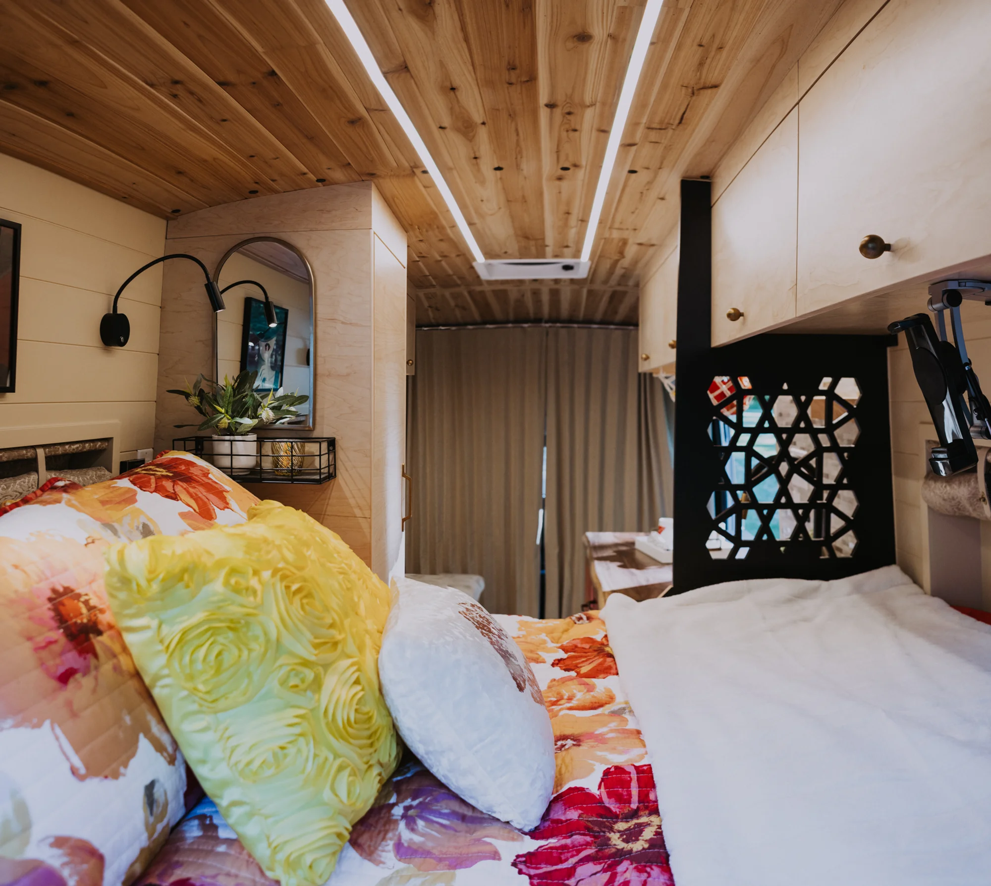 The Drifter 101 custom Ford Transit campervan built for Kim by Drifter Vans, Drifter layout with floral bedding, wood ceiling, and black shower fixtures