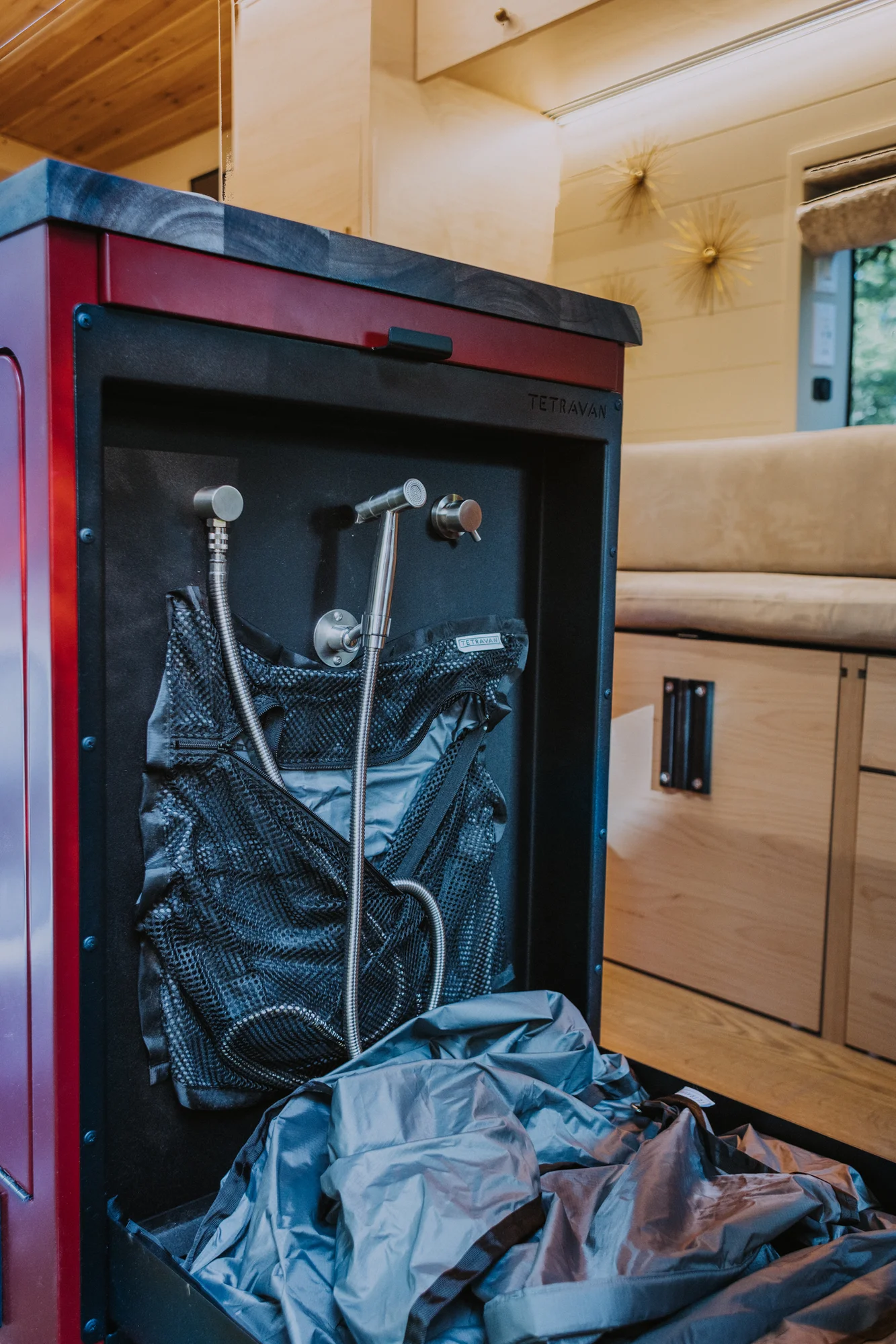 The Drifter 101 custom Ford Transit campervan built for Kim by Drifter Vans, Drifter layout with floral bedding, wood ceiling, and black shower fixtures
