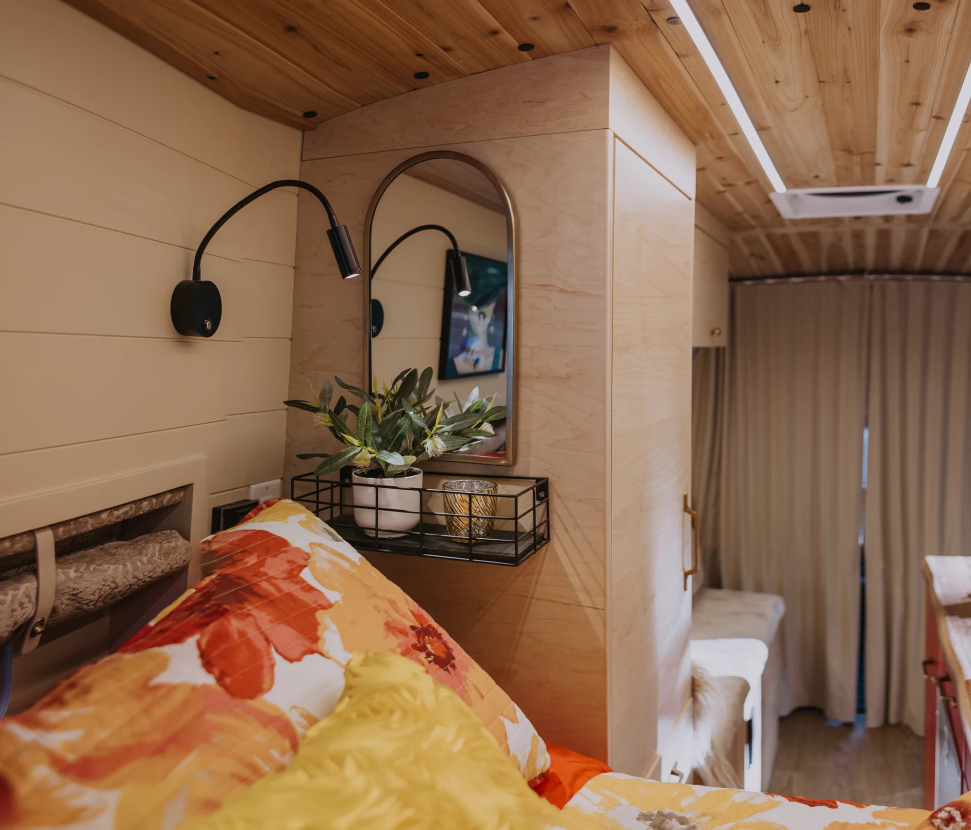 The Drifter 101 custom Ford Transit campervan built for Kim by Drifter Vans, Drifter layout with floral bedding, wood ceiling, and black shower fixtures