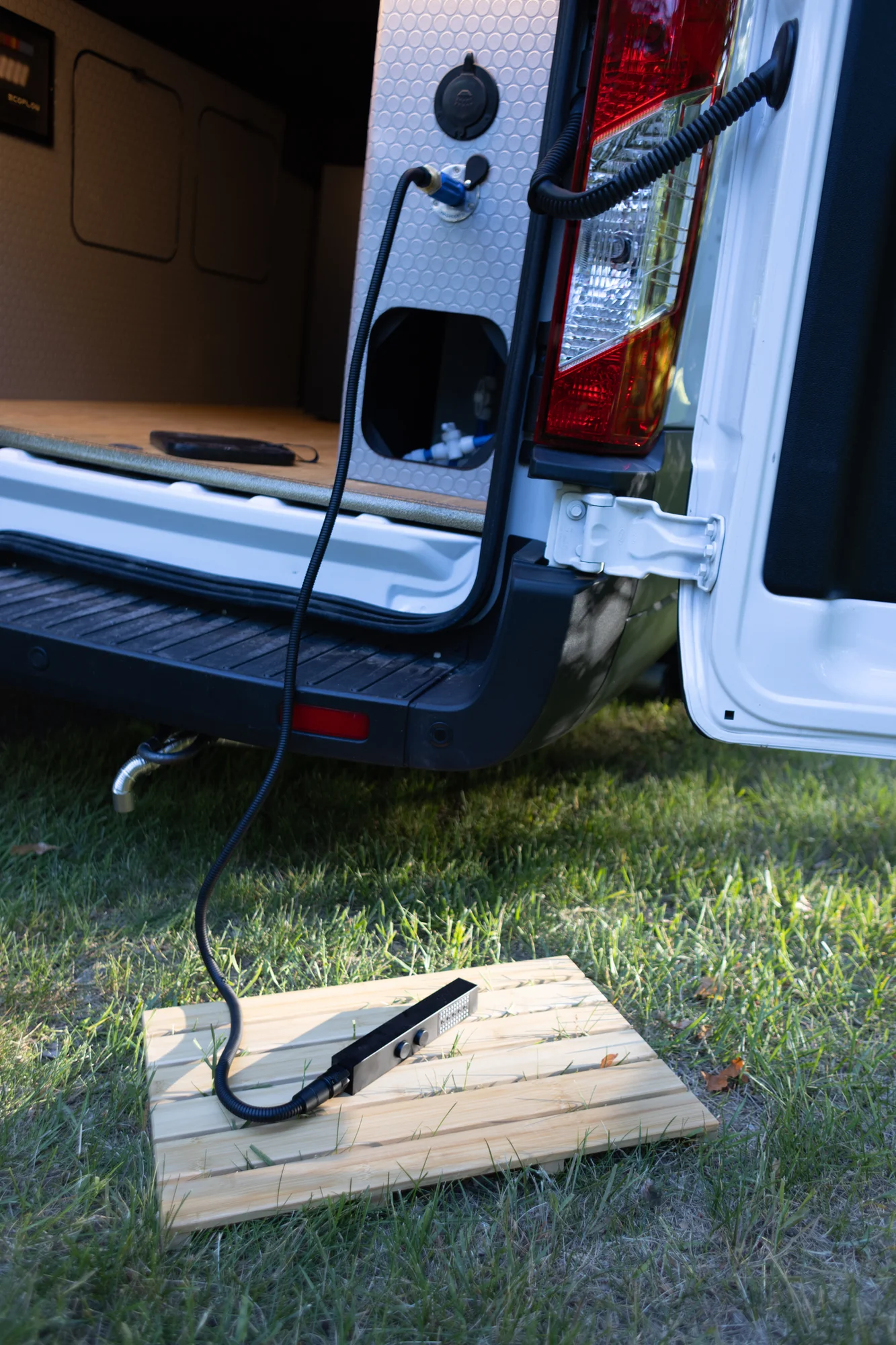 The Drifter 101 custom Ford Transit campervan built for Kim by Drifter Vans, Drifter layout with floral bedding, wood ceiling, and black shower fixtures