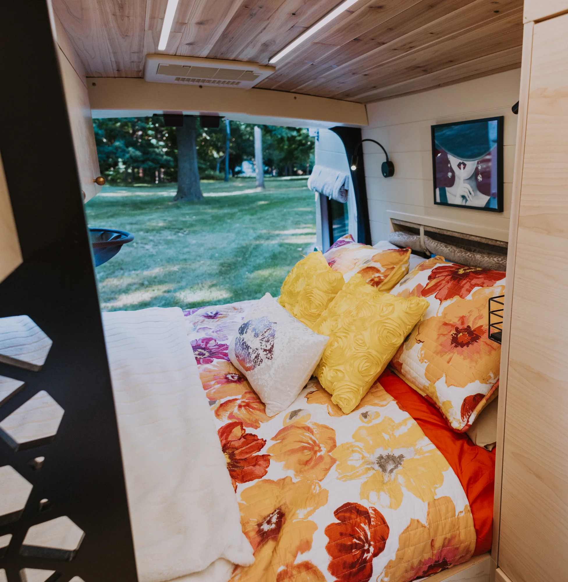 The Drifter 101 custom Ford Transit campervan built for Kim by Drifter Vans, Drifter layout with floral bedding, wood ceiling, and black shower fixtures