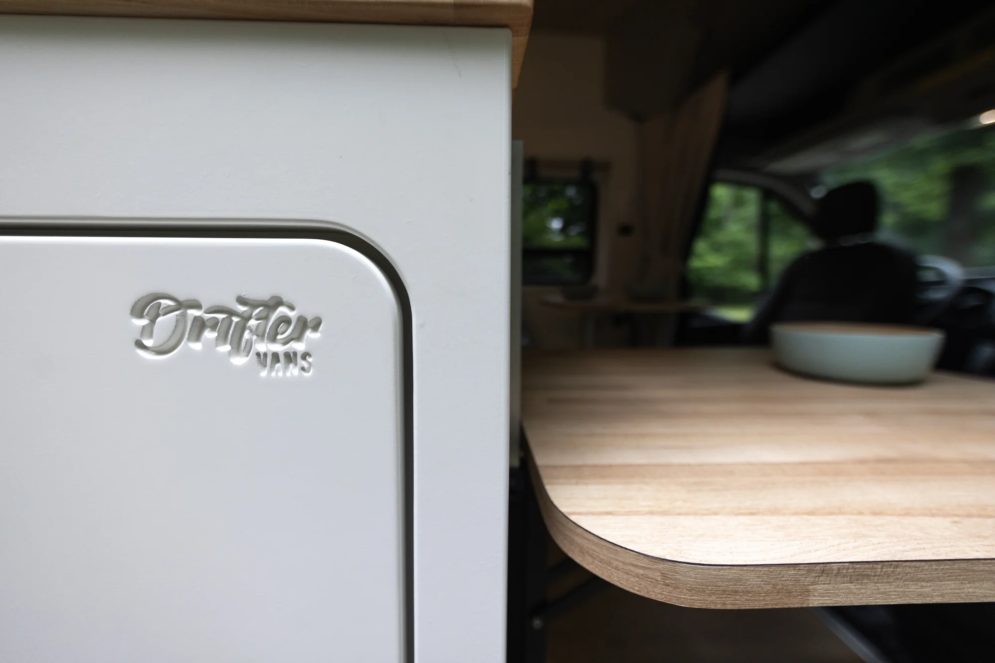 The Drifter 101 custom Ford Transit campervan built for Peter and Linka by Drifter Vans, Scout layout with a coastal interior, light finishes, EcoFlow off-grid power, and a remote work setup