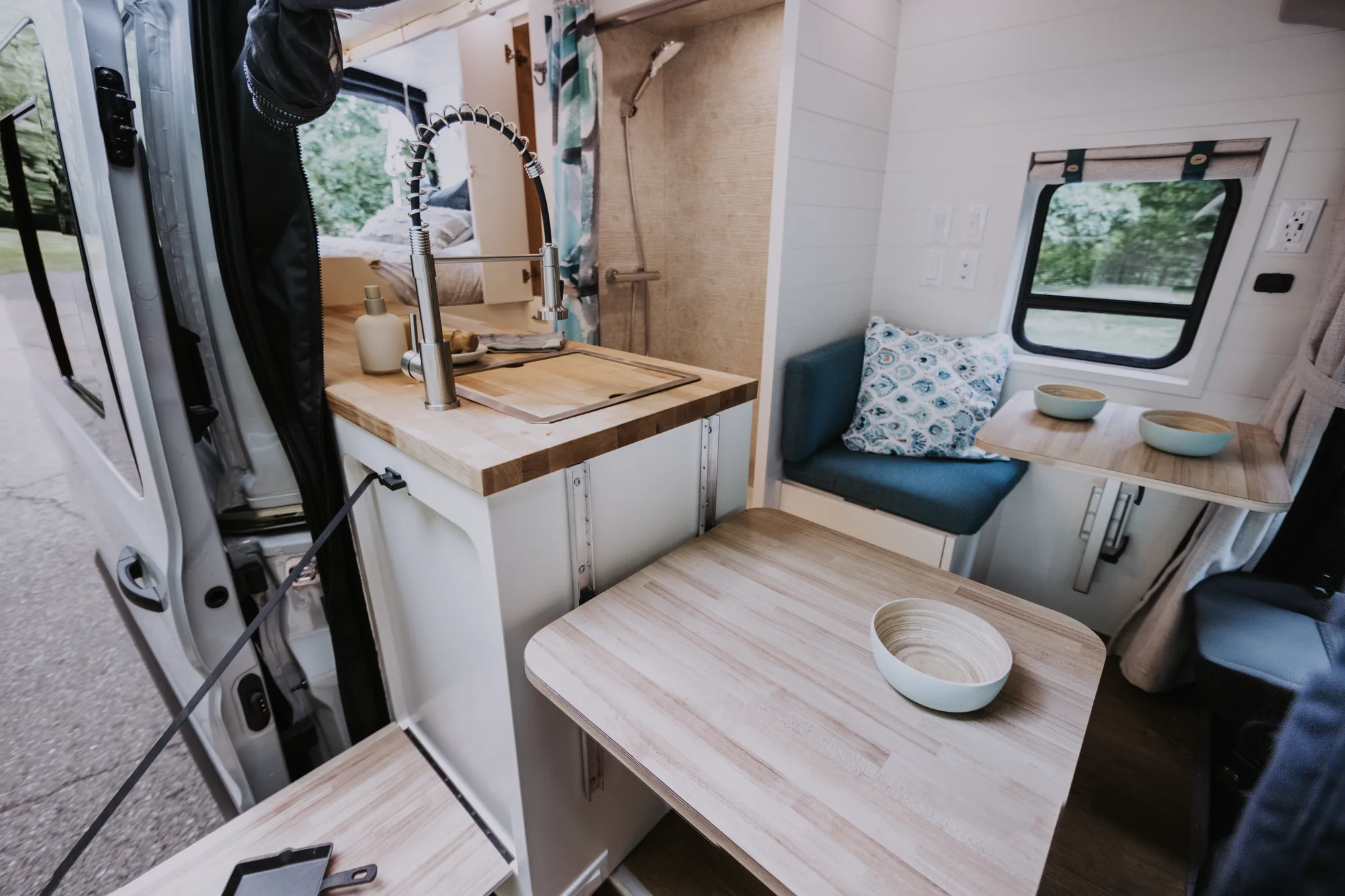 The Drifter 101 custom Ford Transit campervan built for Peter and Linka by Drifter Vans, Scout layout with a coastal interior, light finishes, EcoFlow off-grid power, and a remote work setup