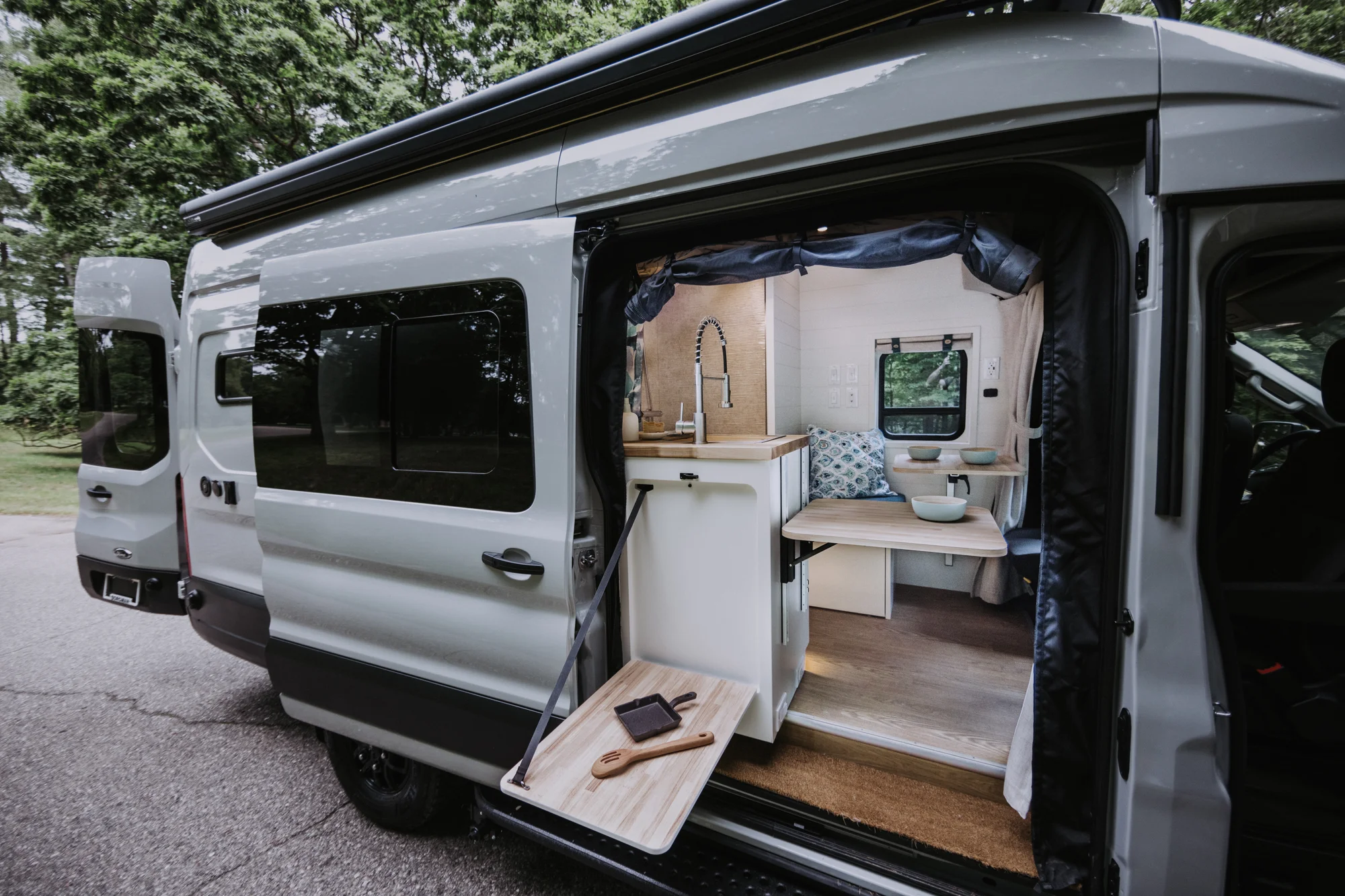 The Drifter 101 custom Ford Transit campervan built for Peter and Linka by Drifter Vans, Scout layout with a coastal interior, light finishes, EcoFlow off-grid power, and a remote work setup