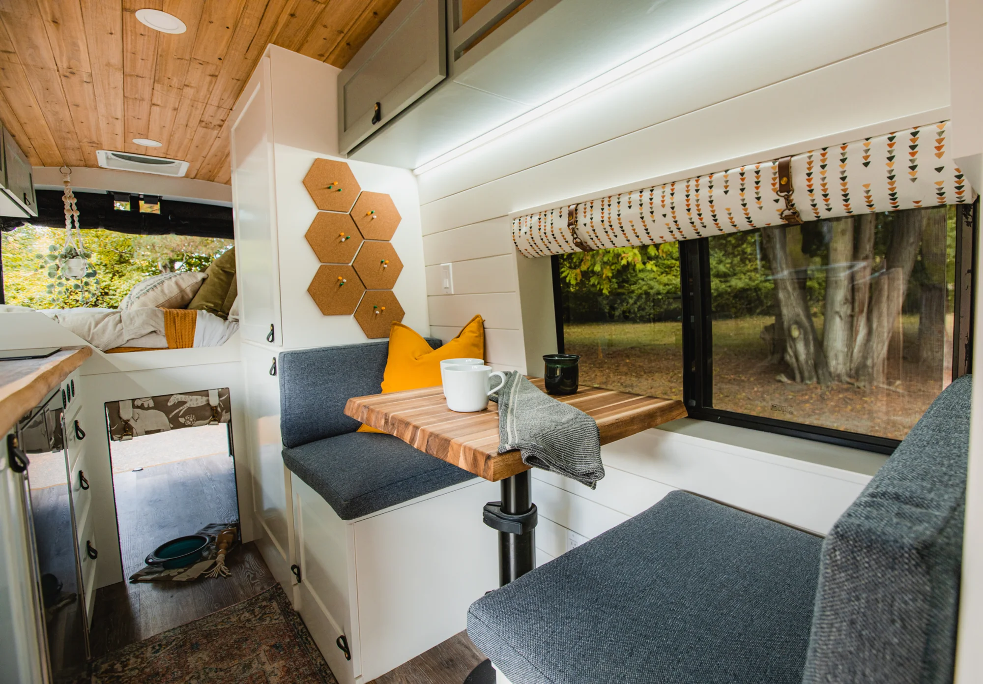 The Drifter 101 custom Ford Transit campervan built for Tess by Drifter Vans, Wanderer layout with a Nordic interior, white shiplap walls, wood ceiling, and gray seating