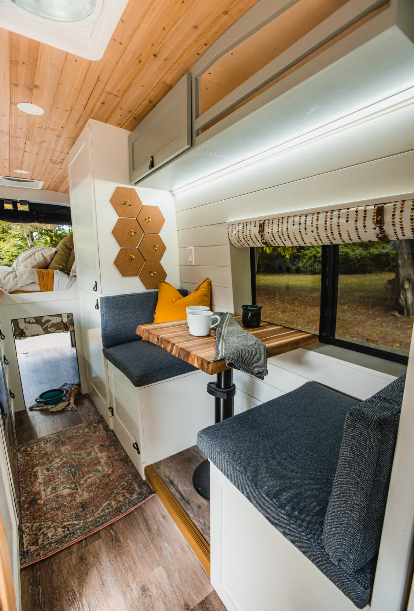The Drifter 101 custom Ford Transit campervan built for Tess by Drifter Vans, Wanderer layout with a Nordic interior, white shiplap walls, wood ceiling, and gray seating