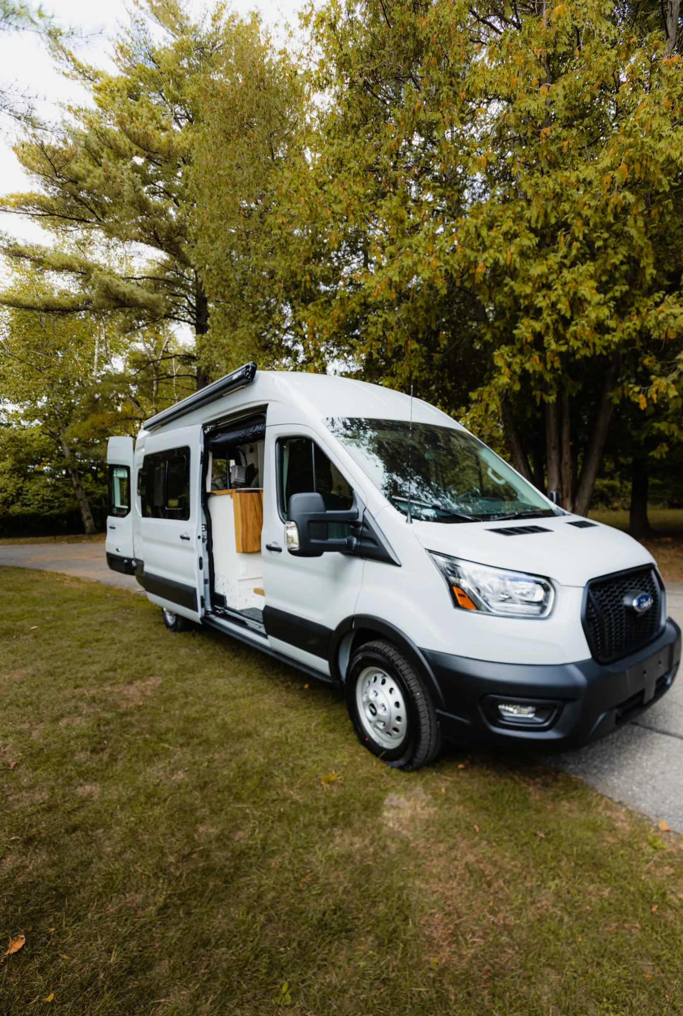 The Drifter 101 custom Ford Transit campervan built for Tess by Drifter Vans, Wanderer layout with a Nordic interior, white shiplap walls, wood ceiling, and gray seating