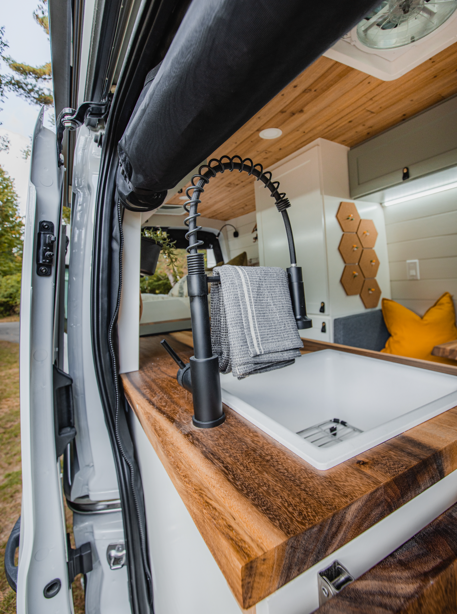 The Drifter 101 custom Ford Transit campervan built for Tess by Drifter Vans, Wanderer layout with a Nordic interior, white shiplap walls, wood ceiling, and gray seating