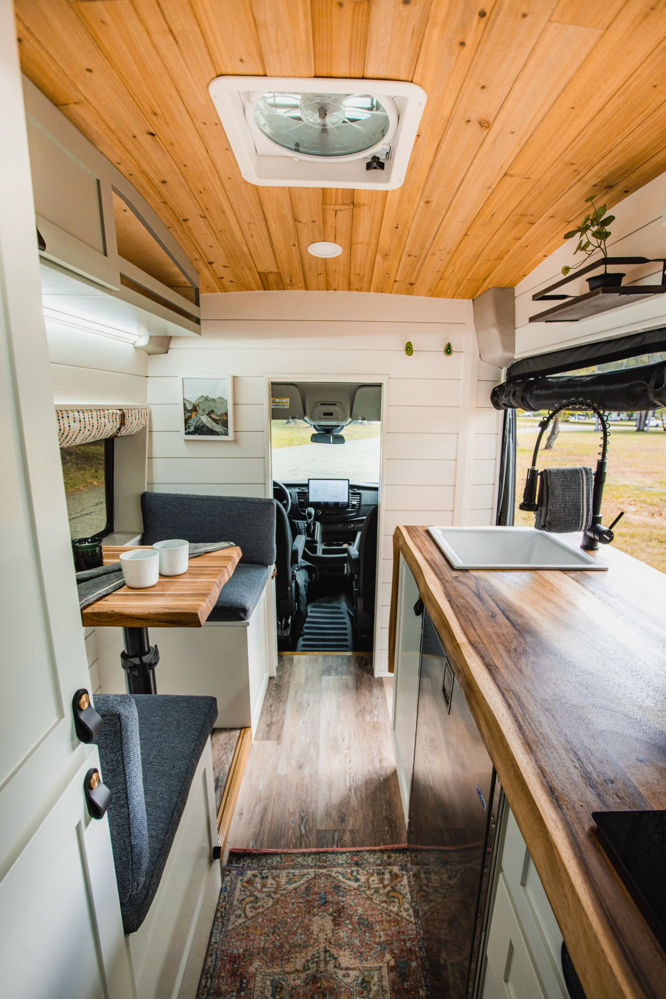 The Drifter 101 custom Ford Transit campervan built for Tess by Drifter Vans, Wanderer layout with a Nordic interior, white shiplap walls, wood ceiling, and gray seating