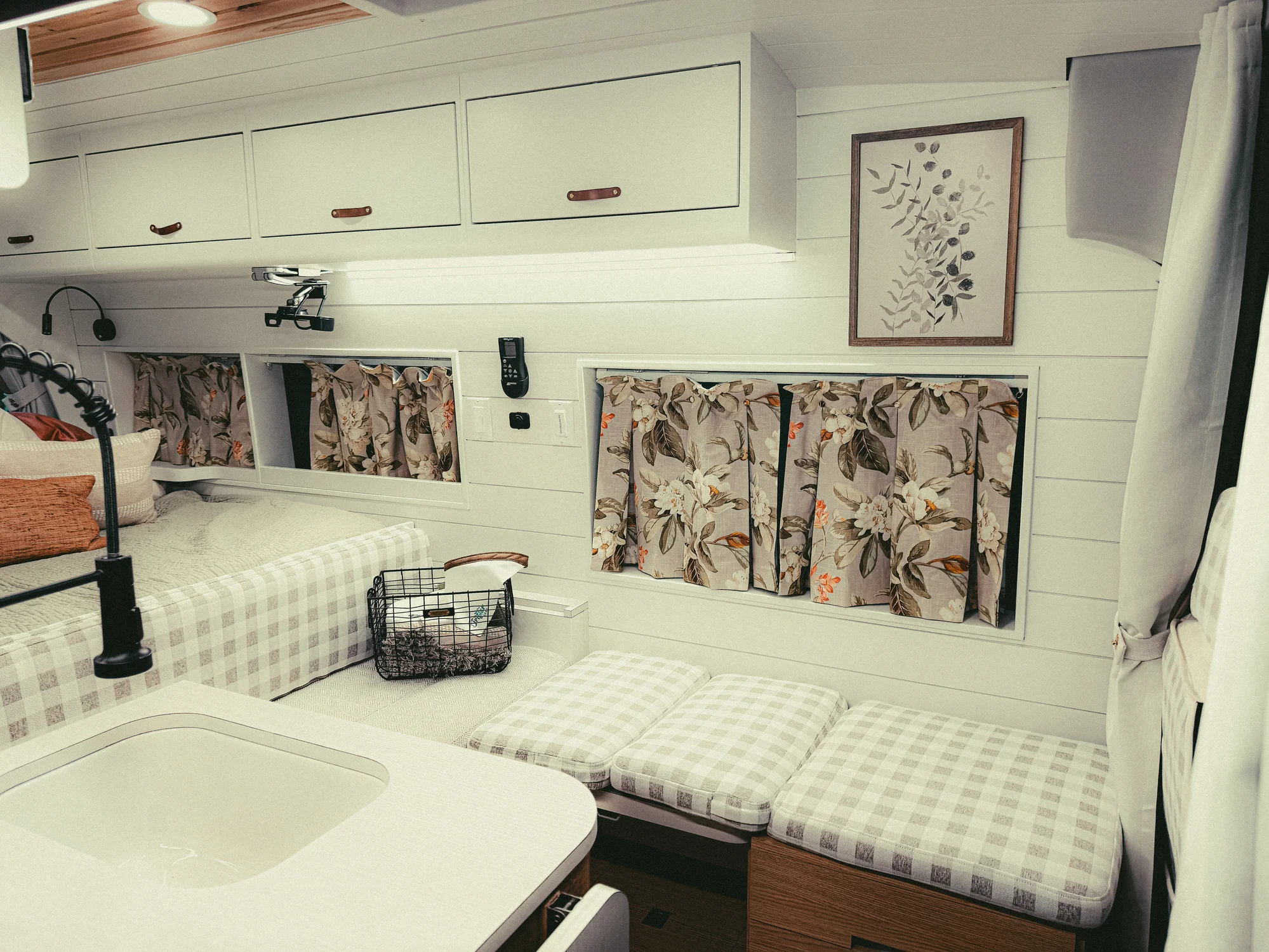 The Drifter 101 custom Ford Transit campervan built for Donna and Stanley by Drifter Vans, farmhouse interior with butcher block countertop, checkered cushions, and floral curtains