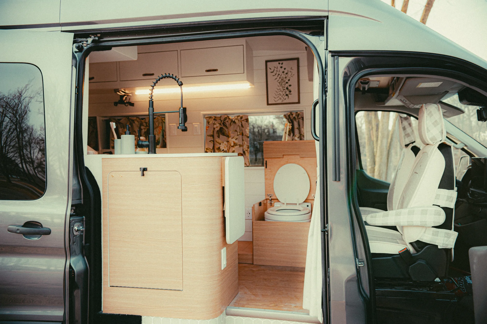 The Drifter 101 custom Ford Transit campervan built for Donna and Stanley by Drifter Vans, farmhouse interior with butcher block countertop, checkered cushions, and floral curtains