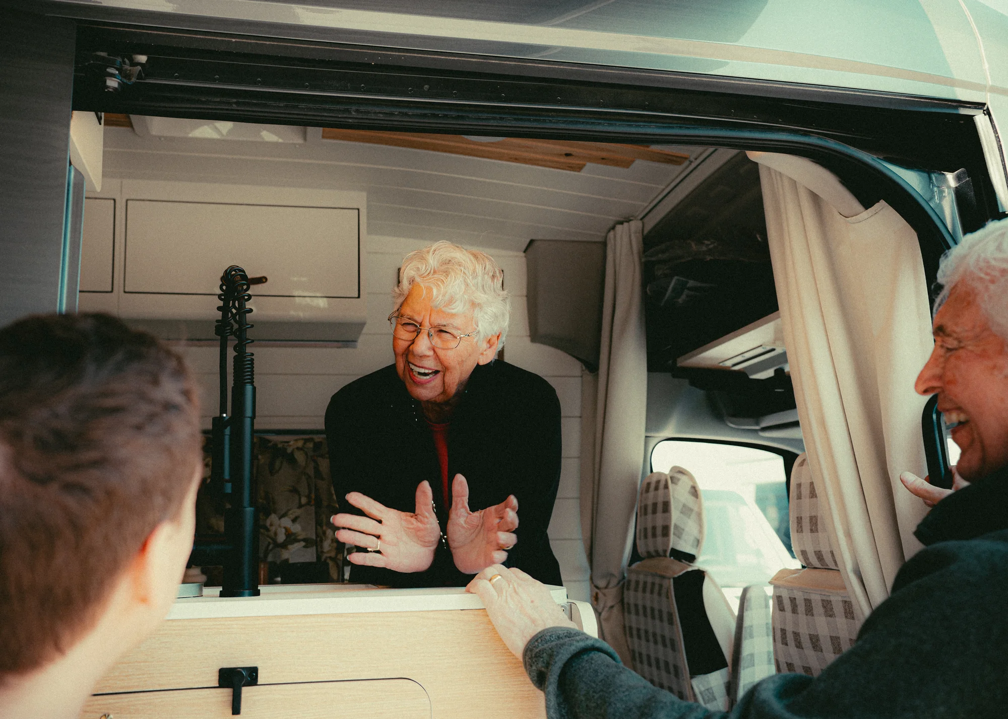 The Drifter 101 custom Ford Transit campervan built for Donna and Stanley by Drifter Vans, farmhouse interior with butcher block countertop, checkered cushions, and floral curtains