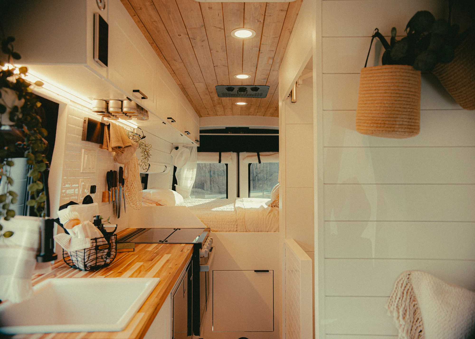 The Drifter 101 custom Ford Transit campervan built for Donna and Stanley by Drifter Vans, farmhouse interior with butcher block countertop, checkered cushions, and floral curtains