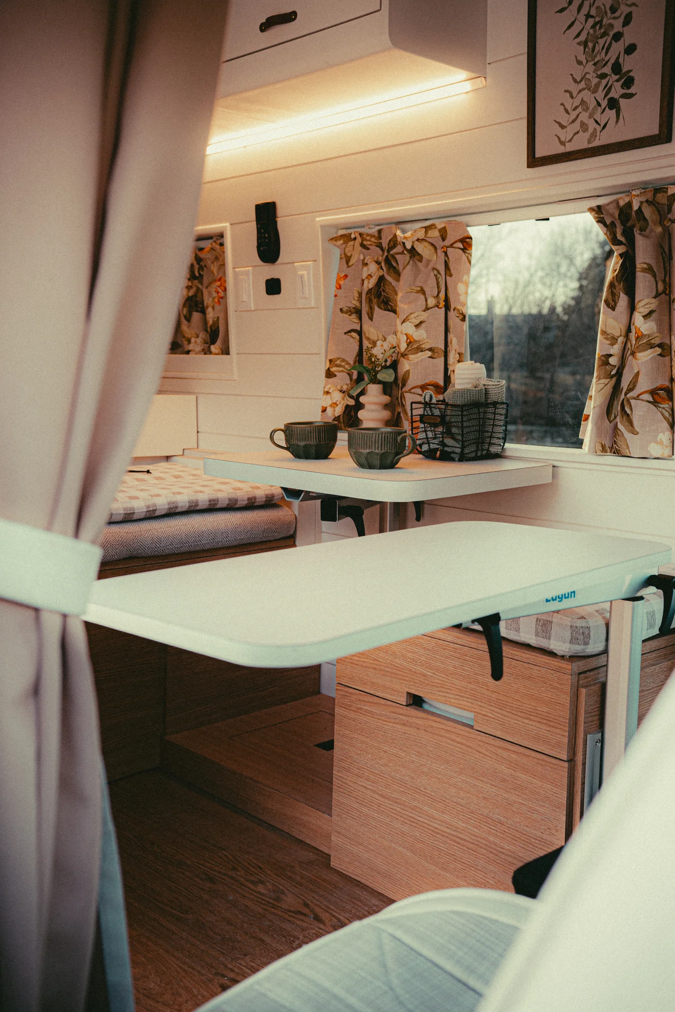 The Drifter 101 custom Ford Transit campervan built for Donna and Stanley by Drifter Vans, farmhouse interior with butcher block countertop, checkered cushions, and floral curtains