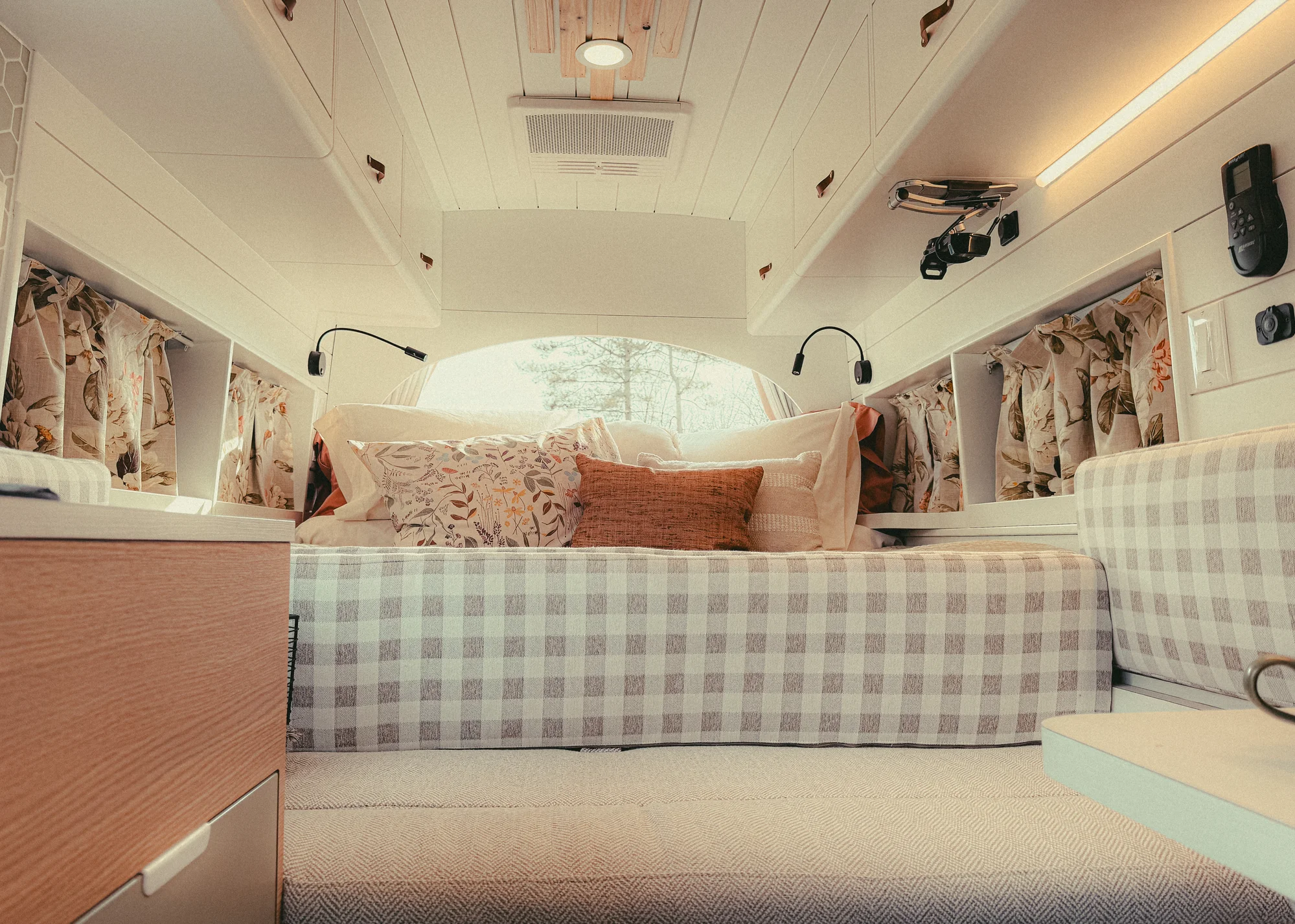 The Drifter 101 custom Ford Transit campervan built for Donna and Stanley by Drifter Vans, farmhouse interior with butcher block countertop, checkered cushions, and floral curtains