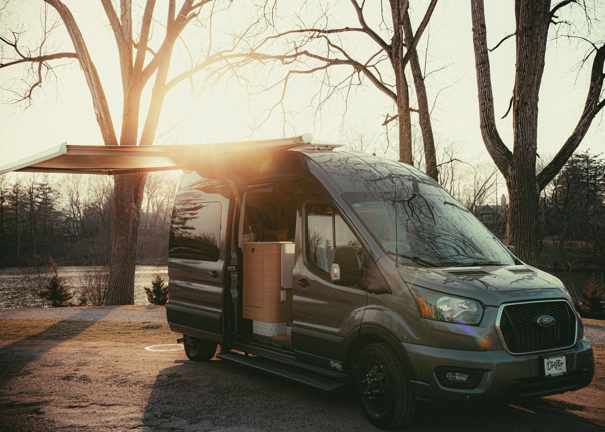 The Drifter 101 custom Ford Transit campervan built for Donna and Stanley by Drifter Vans, farmhouse interior with butcher block countertop, checkered cushions, and floral curtains