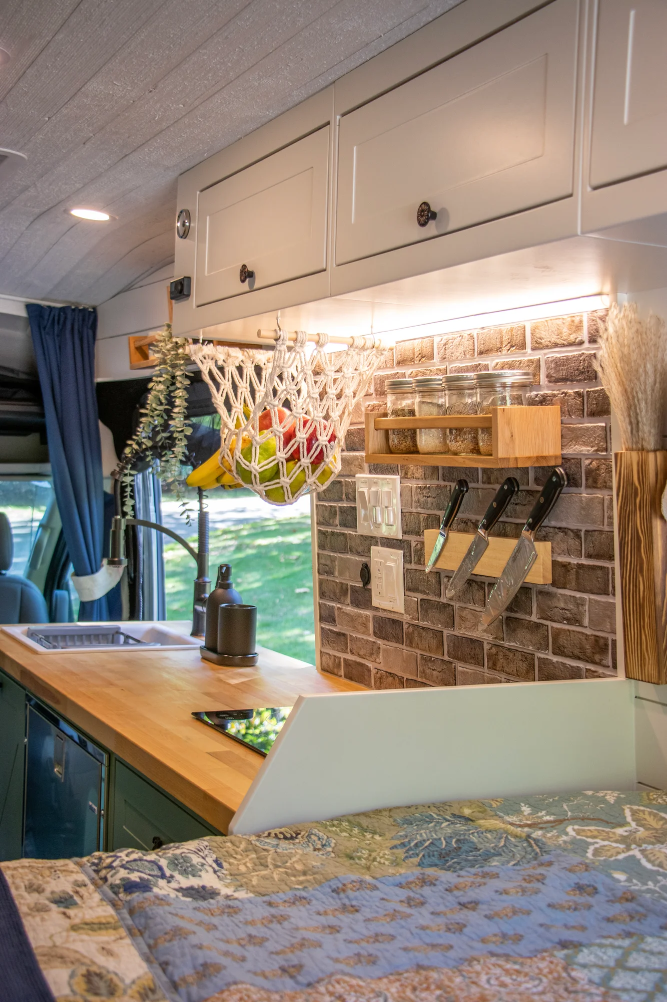 The Drifter 101 custom Ford Transit campervan built for Steph and Jen by Drifter Vans, Wanderer layout with a brick backsplash, sage green cabinetry, and farmhouse lighting