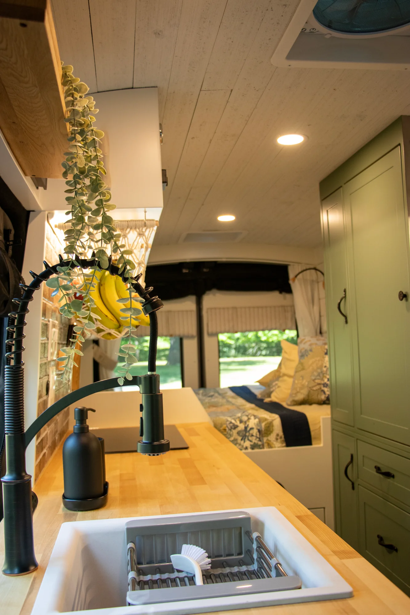 The Drifter 101 custom Ford Transit campervan built for Steph and Jen by Drifter Vans, Wanderer layout with a brick backsplash, sage green cabinetry, and farmhouse lighting