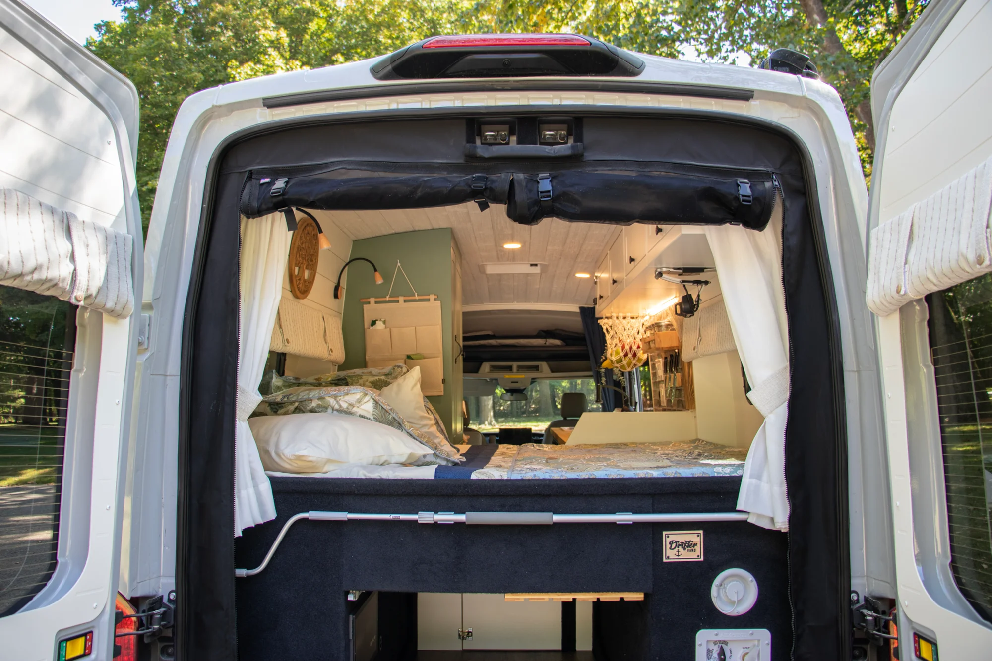 The Drifter 101 custom Ford Transit campervan built for Steph and Jen by Drifter Vans, Wanderer layout with a brick backsplash, sage green cabinetry, and farmhouse lighting