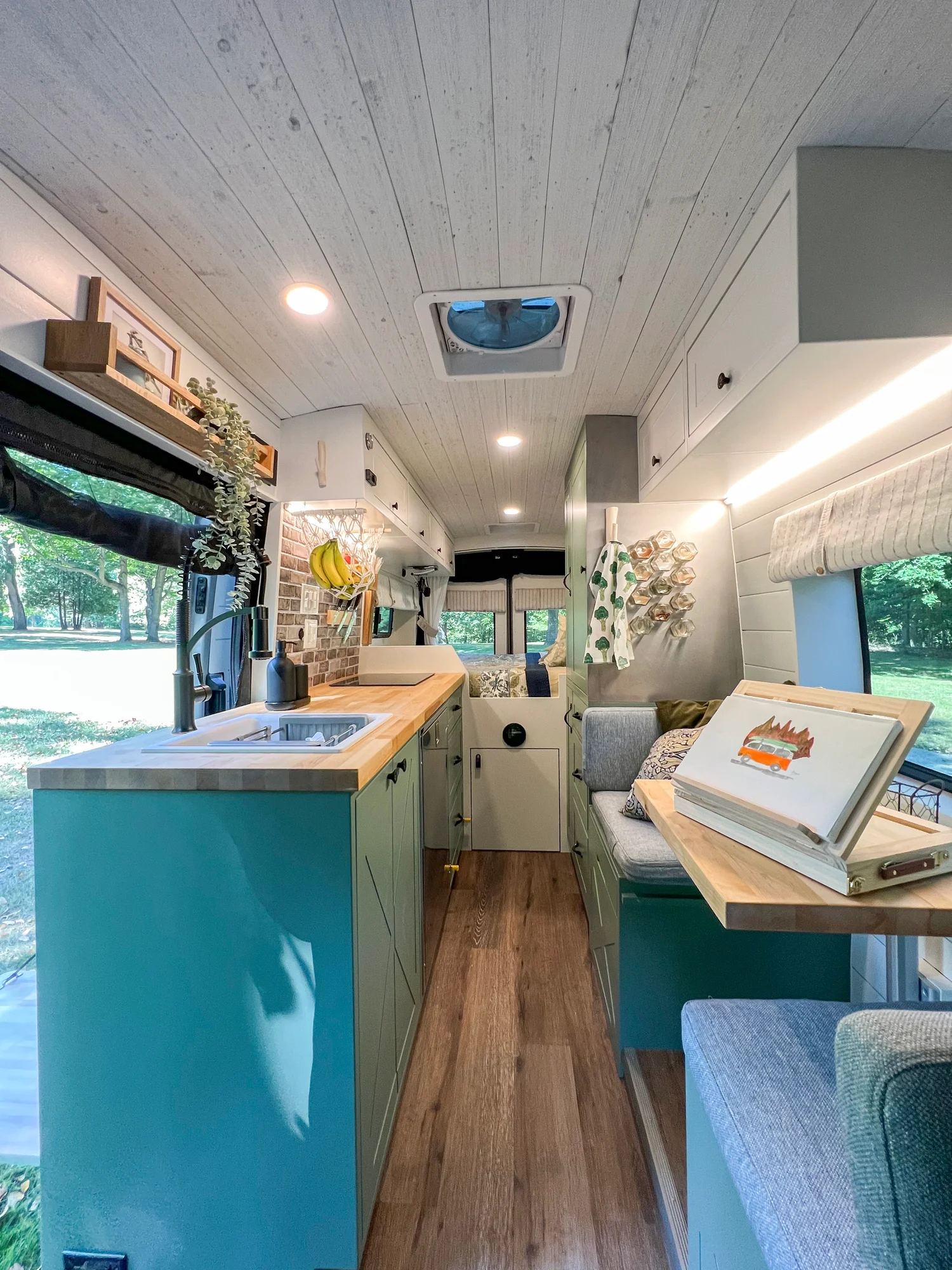 The Drifter 101 custom Ford Transit campervan built for Steph and Jen by Drifter Vans, Wanderer layout with a brick backsplash, sage green cabinetry, and farmhouse lighting