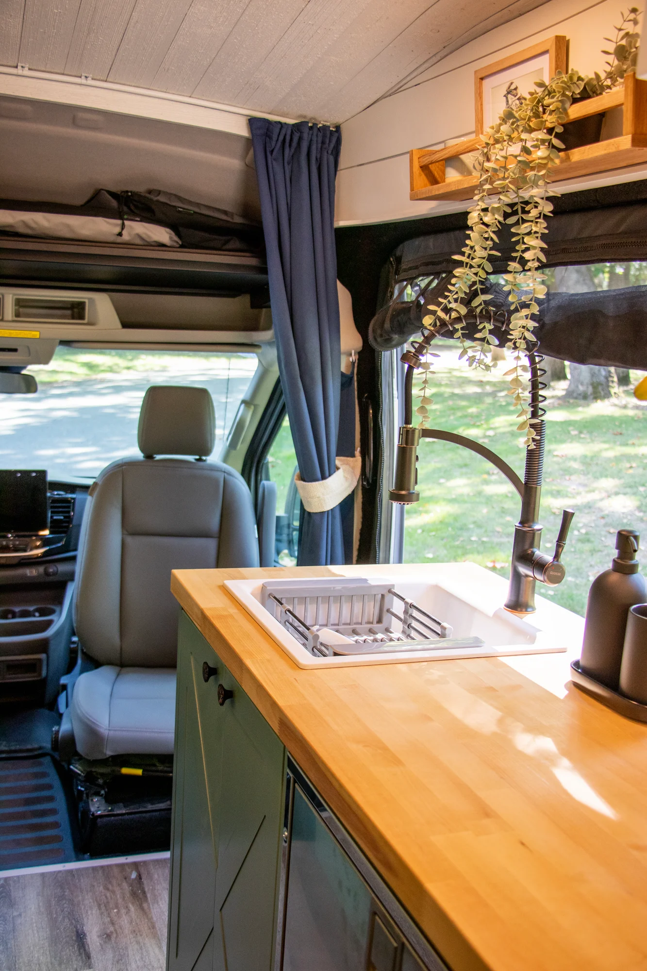 The Drifter 101 custom Ford Transit campervan built for Steph and Jen by Drifter Vans, Wanderer layout with a brick backsplash, sage green cabinetry, and farmhouse lighting