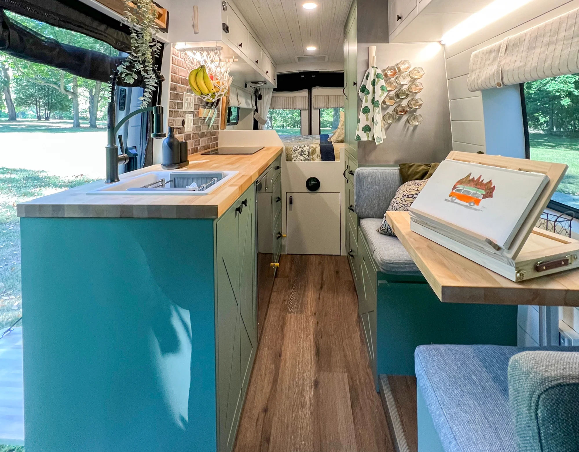 The Drifter 101 custom Ford Transit campervan built for Steph and Jen by Drifter Vans, Wanderer layout with a brick backsplash, sage green cabinetry, and farmhouse lighting