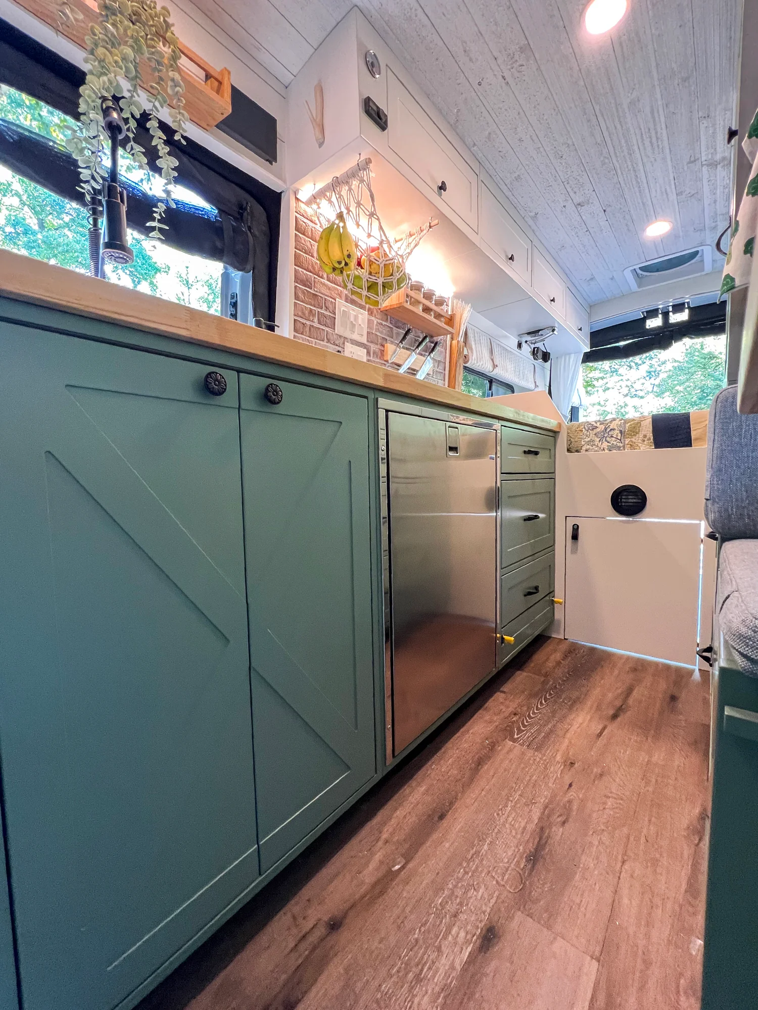 The Drifter 101 custom Ford Transit campervan built for Steph and Jen by Drifter Vans, Wanderer layout with a brick backsplash, sage green cabinetry, and farmhouse lighting