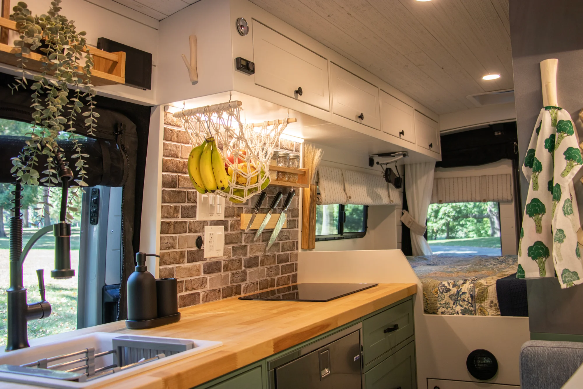 The Drifter 101 custom Ford Transit campervan built for Steph and Jen by Drifter Vans, Wanderer layout with a brick backsplash, sage green cabinetry, and farmhouse lighting