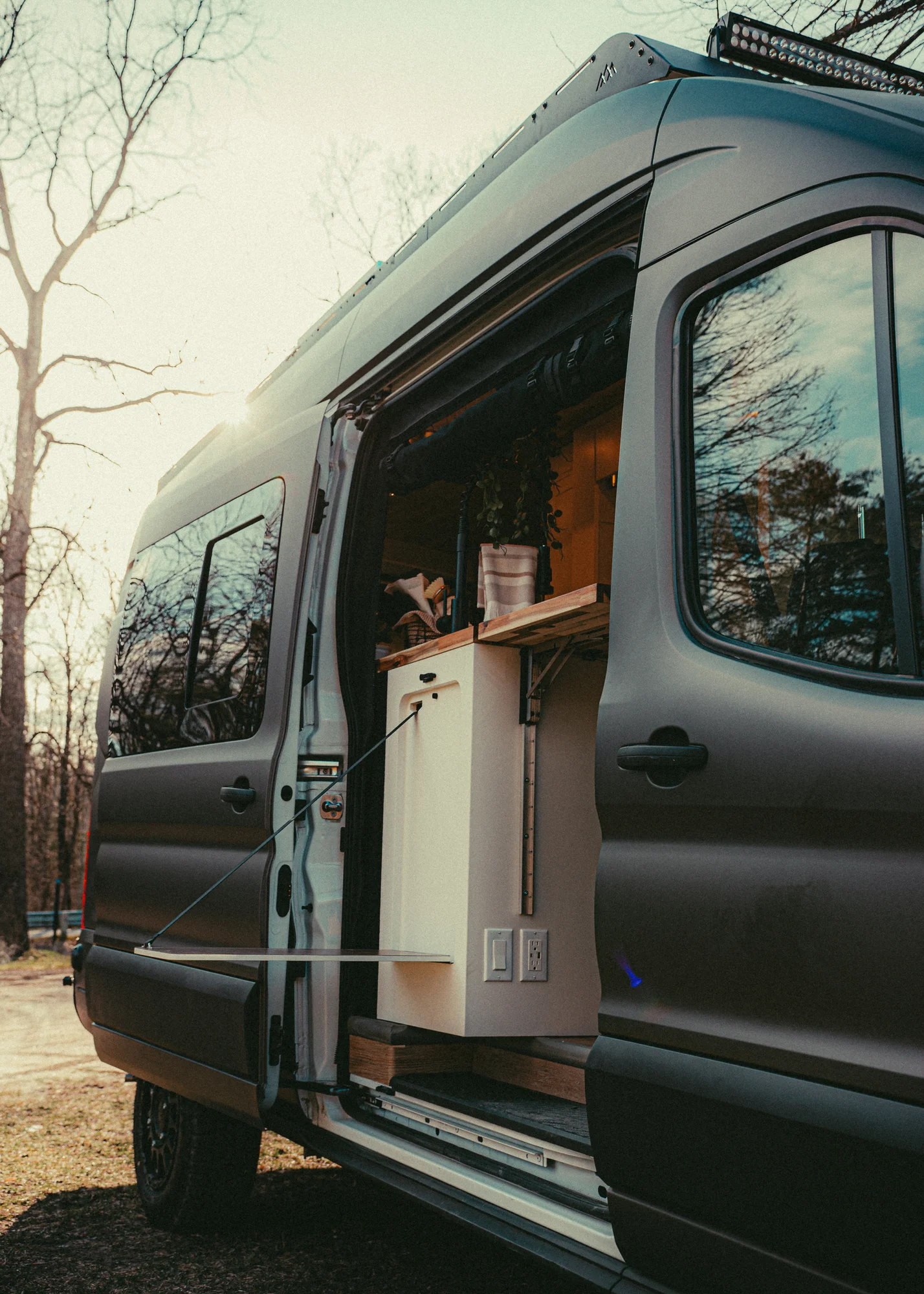 The Drifter 101 custom Ford Transit campervan built for Kyle and Zoe by Drifter Vans, Scout layout with white shiplap walls, light wood cabinetry, and a coastal-inspired interior