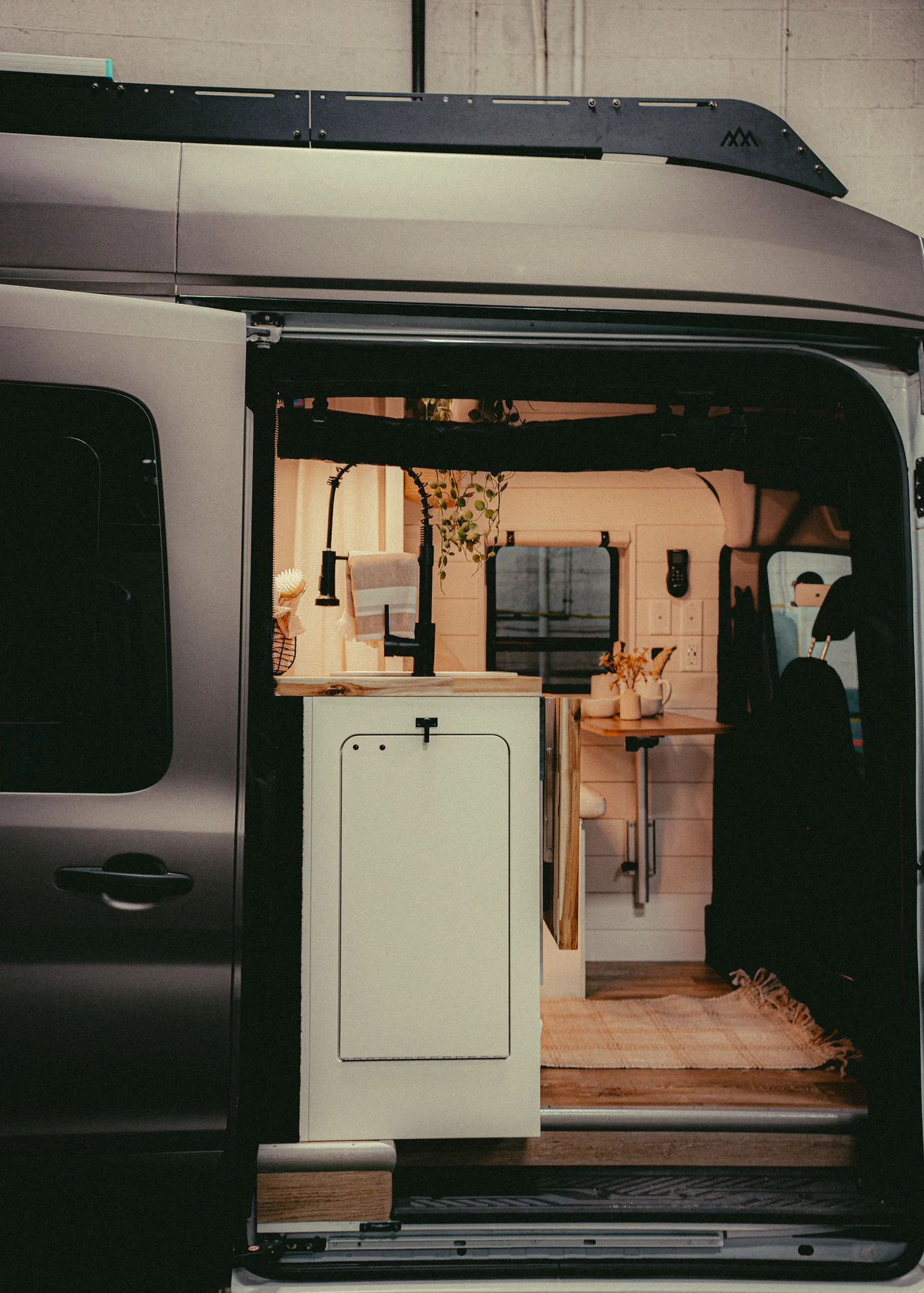 The Drifter 101 custom Ford Transit campervan built for Kyle and Zoe by Drifter Vans, Scout layout with white shiplap walls, light wood cabinetry, and a coastal-inspired interior