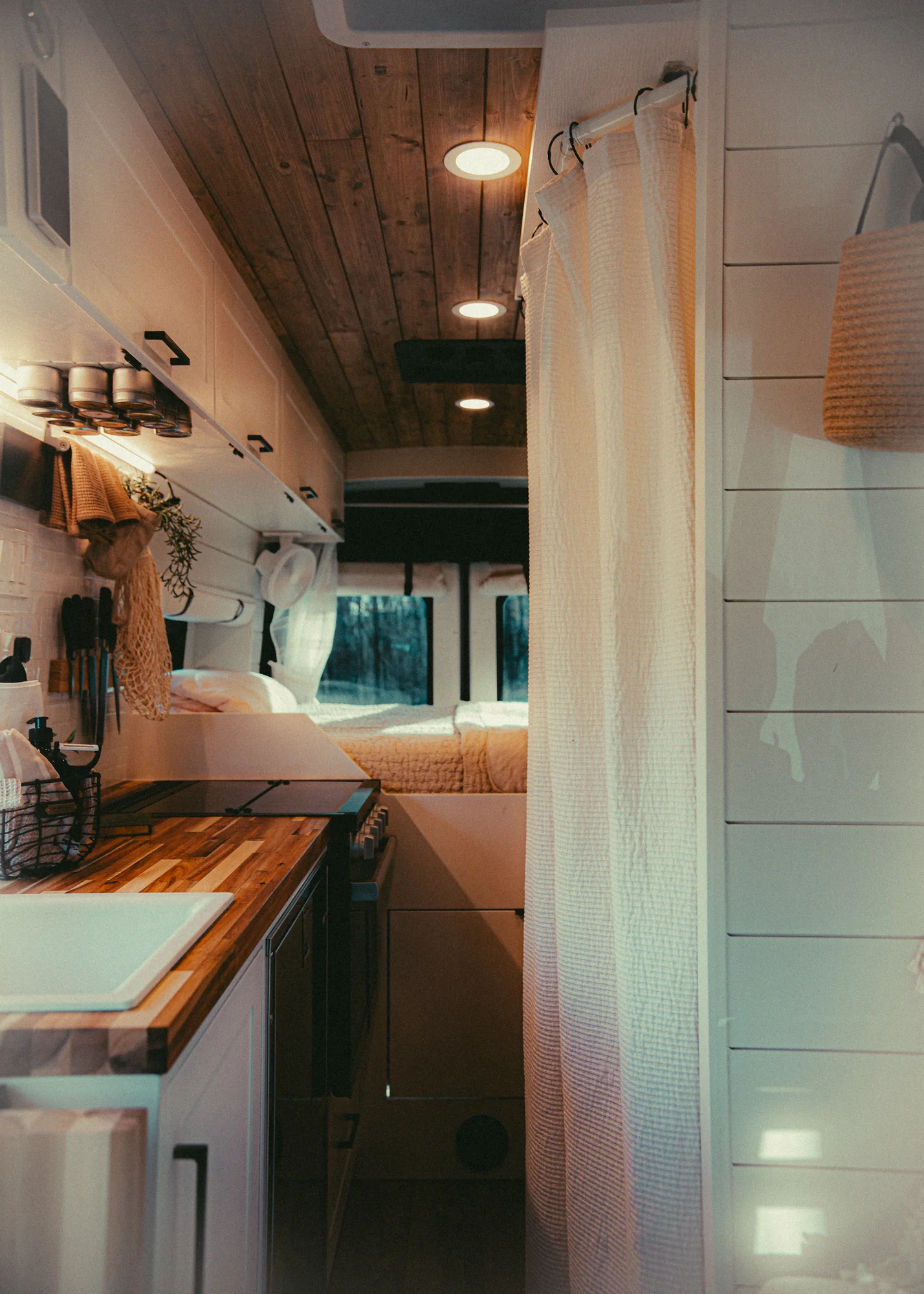The Drifter 101 custom Ford Transit campervan built for Kyle and Zoe by Drifter Vans, Scout layout with white shiplap walls, light wood cabinetry, and a coastal-inspired interior