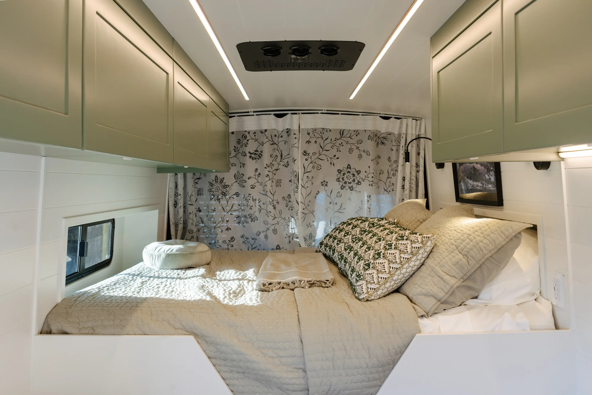 The Drifter 101 custom Ford Transit campervan built for Linda by Drifter Vans, Wanderer layout with sage green cabinetry, floral curtains, and a farmhouse-style interior