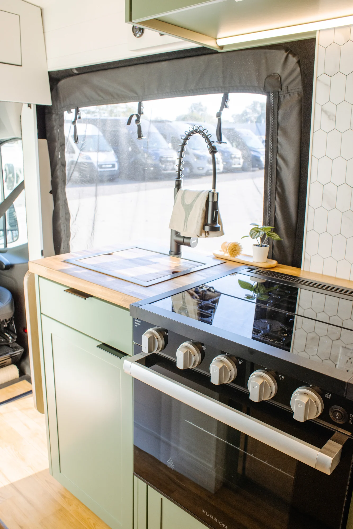 The Drifter 101 custom Ford Transit campervan built for Linda by Drifter Vans, Wanderer layout with sage green cabinetry, floral curtains, and a farmhouse-style interior