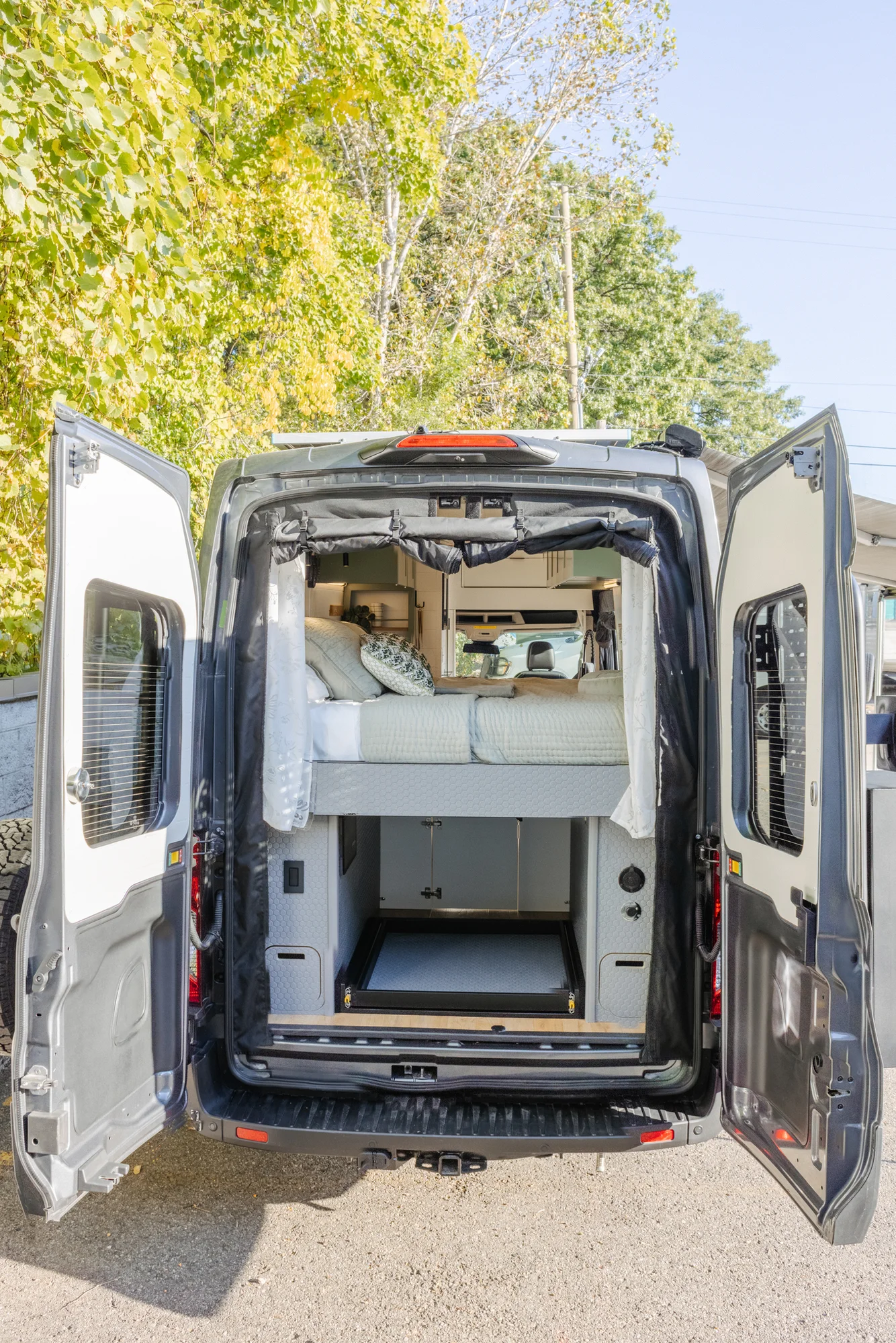 The Drifter 101 custom Ford Transit campervan built for Linda by Drifter Vans, Wanderer layout with sage green cabinetry, floral curtains, and a farmhouse-style interior