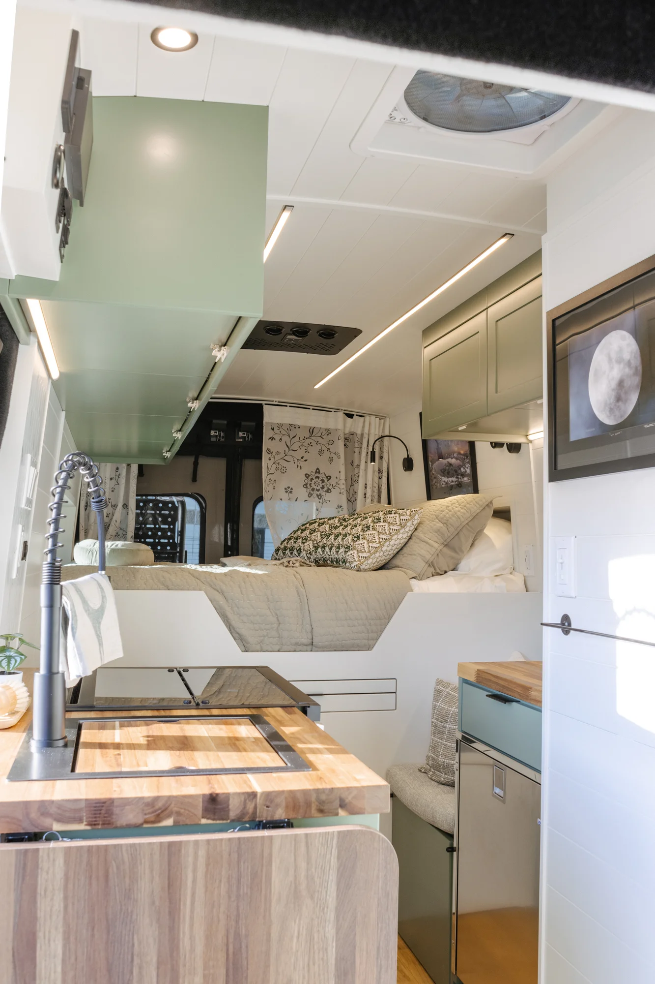 The Drifter 101 custom Ford Transit campervan built for Linda by Drifter Vans, Wanderer layout with sage green cabinetry, floral curtains, and a farmhouse-style interior