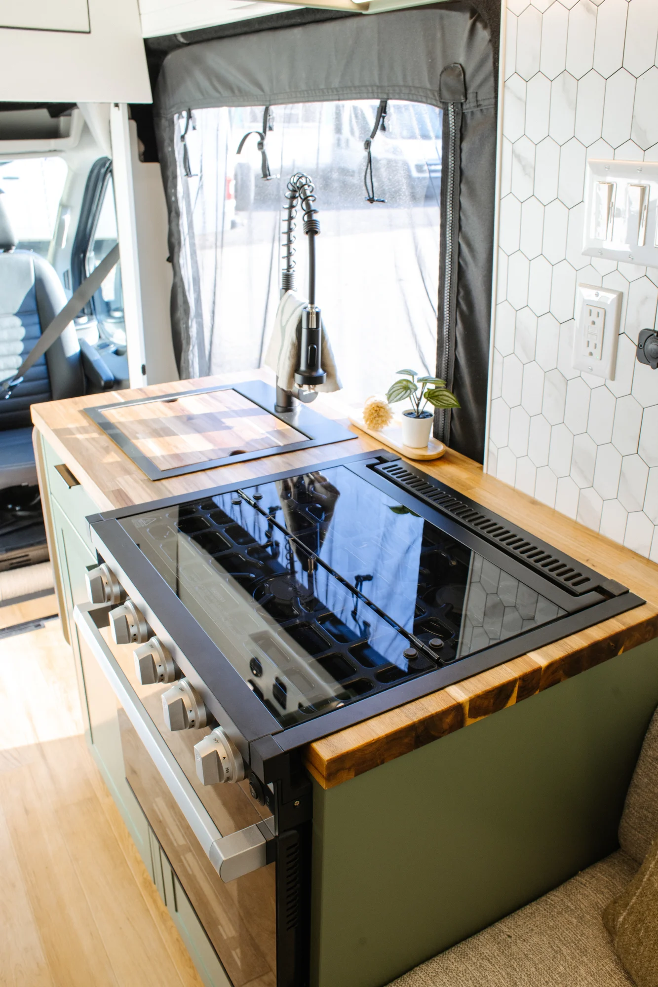The Drifter 101 custom Ford Transit campervan built for Linda by Drifter Vans, Wanderer layout with sage green cabinetry, floral curtains, and a farmhouse-style interior