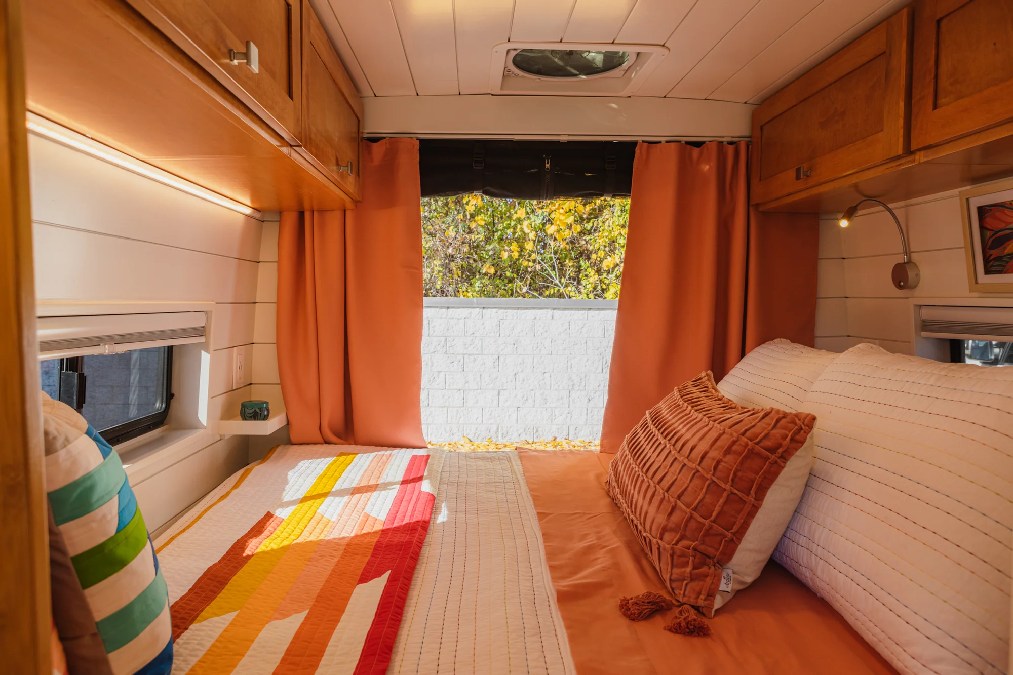 The Drifter 101 custom Ford Transit campervan built for Griff by Drifter Vans, with a bold orange and white interior, herringbone backsplash, and gray tile shower