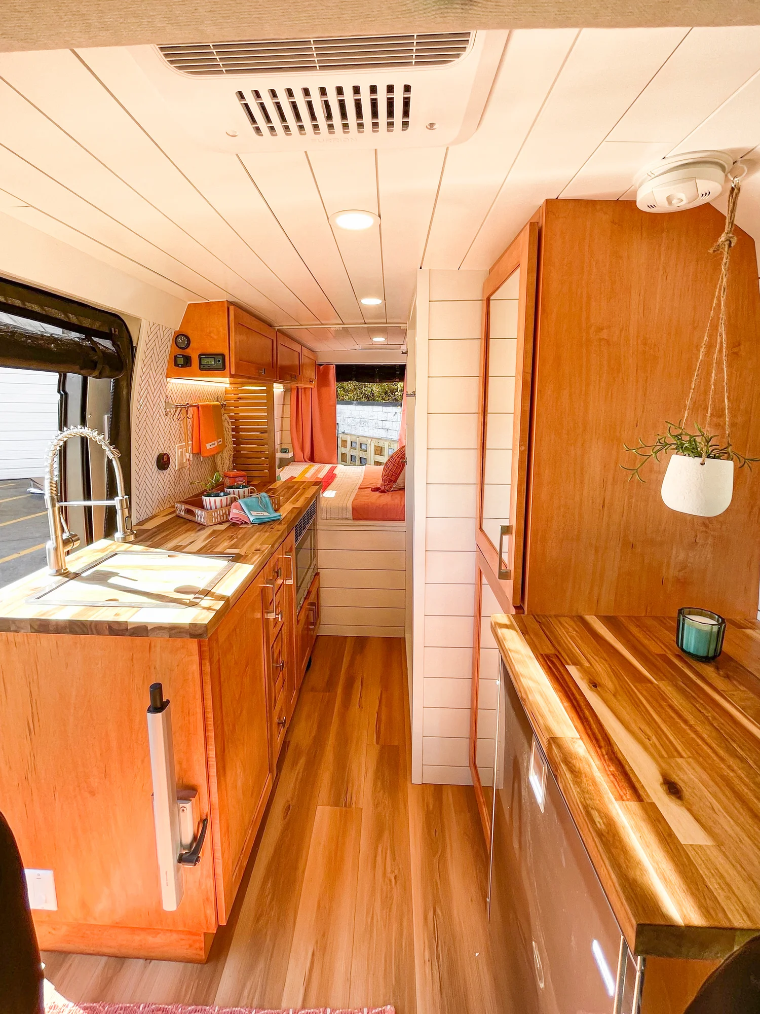 The Drifter 101 custom Ford Transit campervan built for Griff by Drifter Vans, with a bold orange and white interior, herringbone backsplash, and gray tile shower