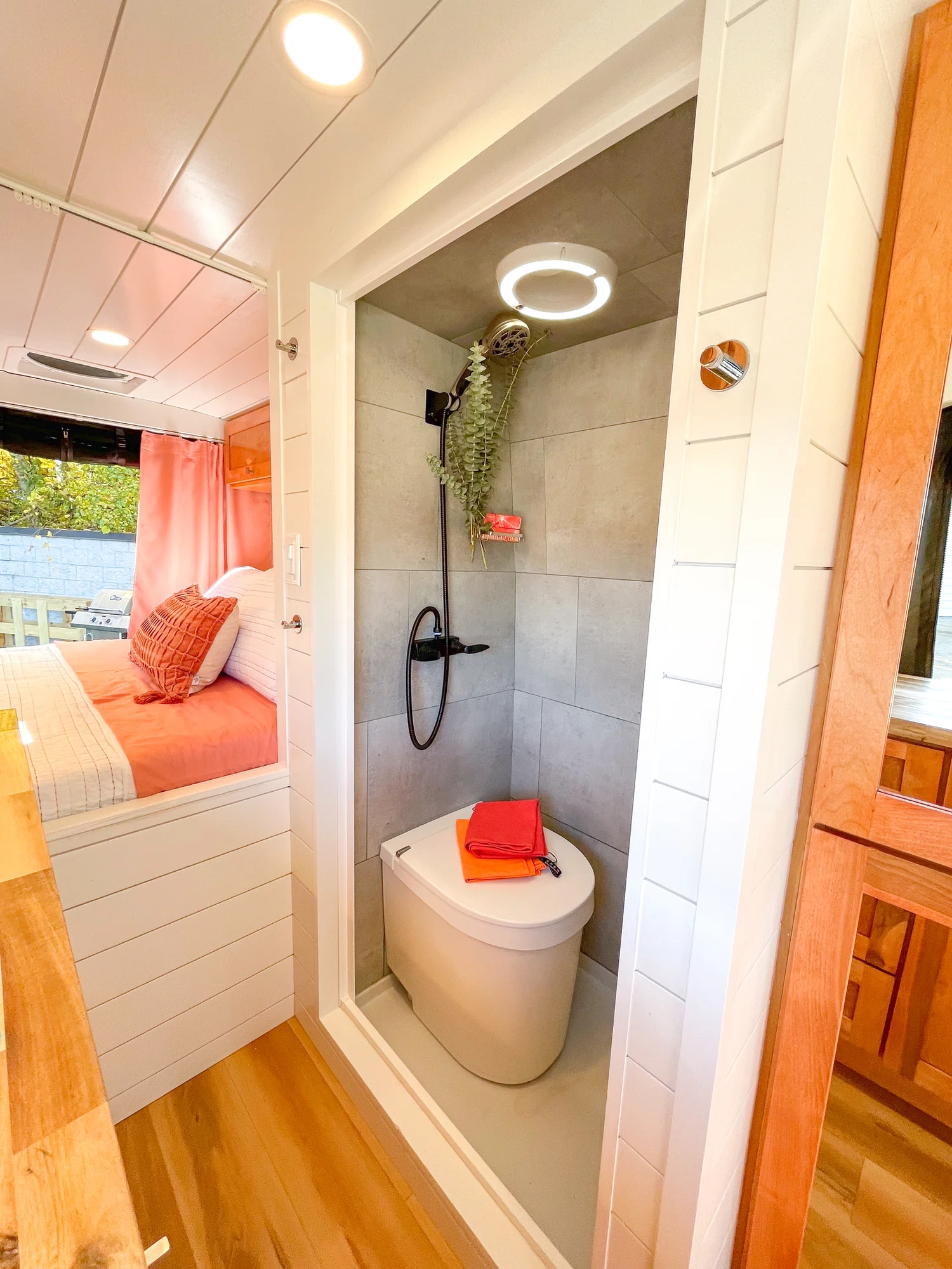 The Drifter 101 custom Ford Transit campervan built for Griff by Drifter Vans, with a bold orange and white interior, herringbone backsplash, and gray tile shower