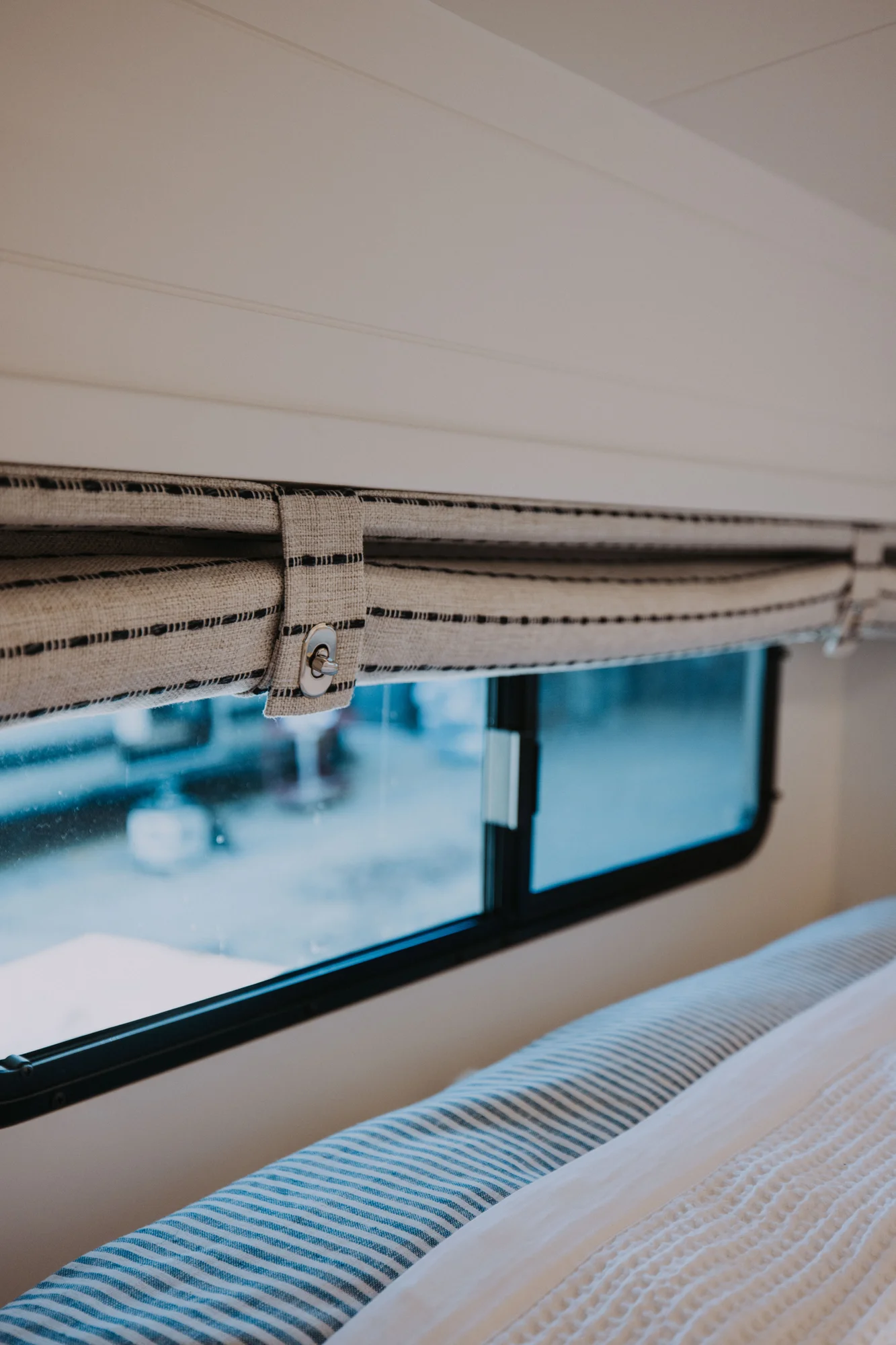 The Drifter 101 custom Ford Transit campervan built for Ayala by Drifter Vans, Drifter layout with warm wood cabinetry, a blue backsplash, flip-down shower, and an Avalanche Grey exterior