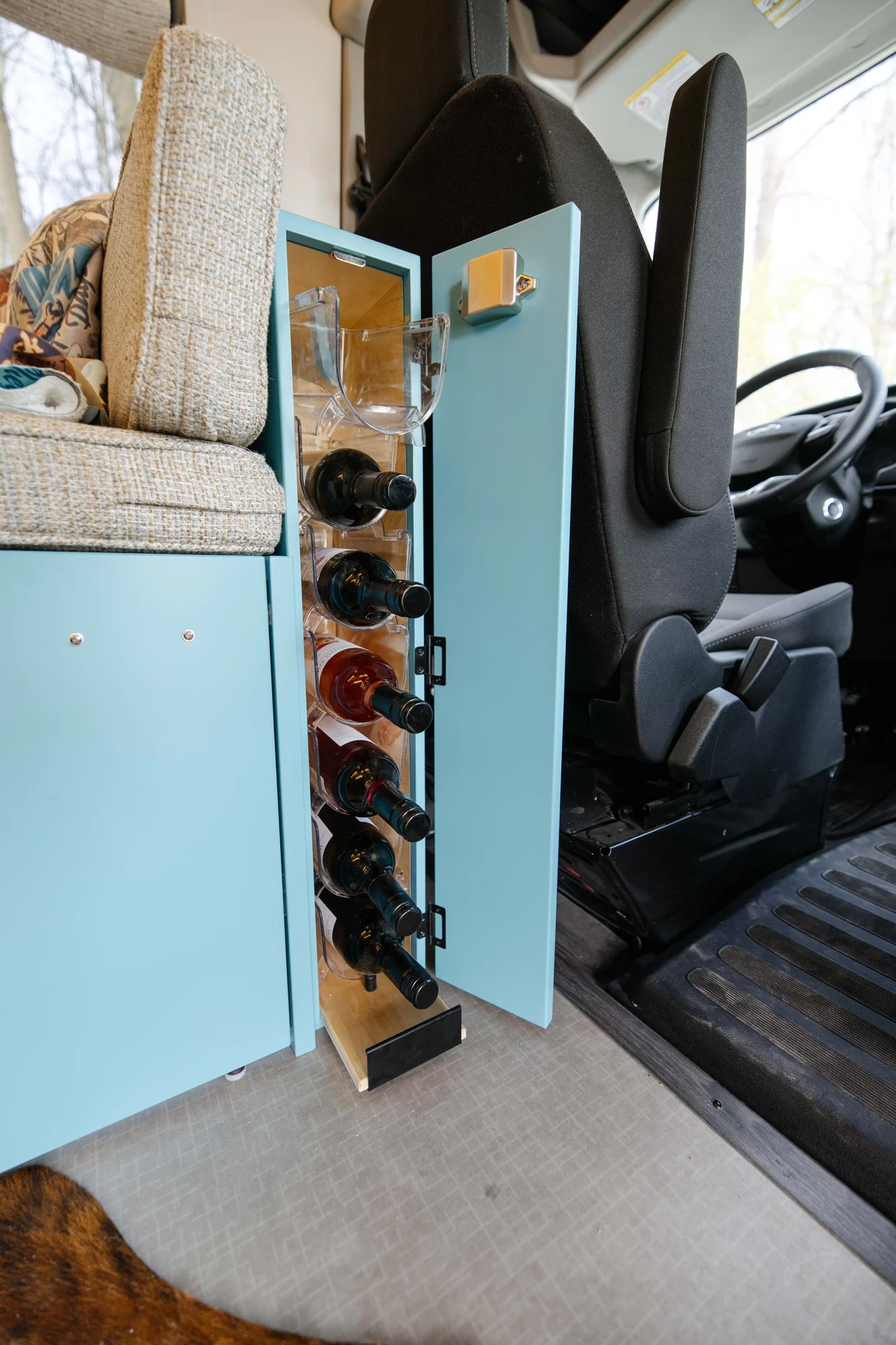 The Drifter 101 custom Ford Transit campervan built for Zach and Stephanie by Drifter Vans, with turquoise cabinetry, a custom wine rack, and Texas-inspired mid-century details