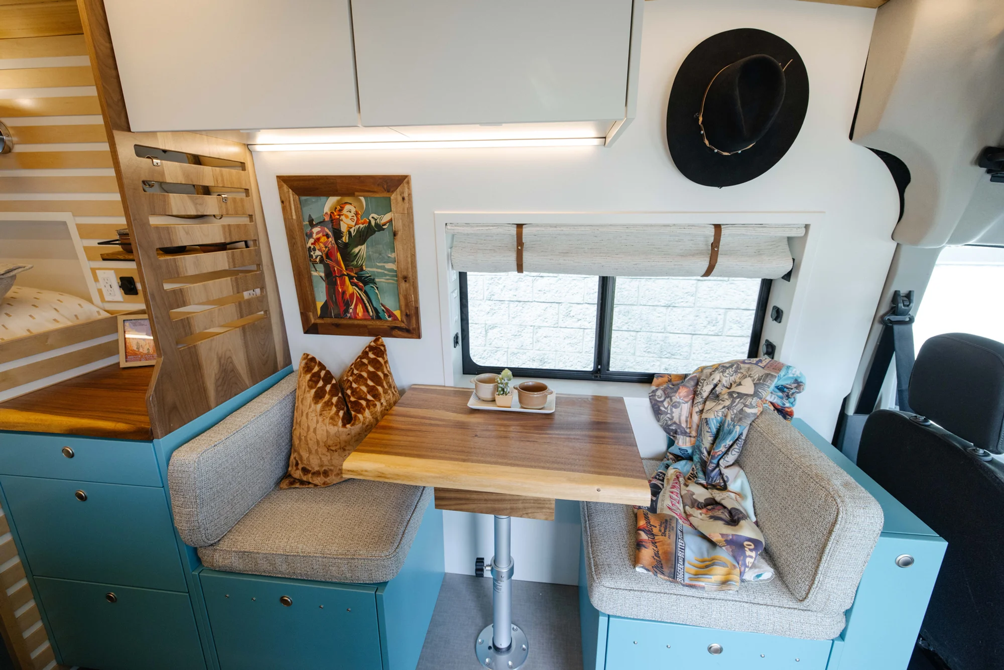 The Drifter 101 custom Ford Transit campervan built for Zach and Stephanie by Drifter Vans, with turquoise cabinetry, a custom wine rack, and Texas-inspired mid-century details