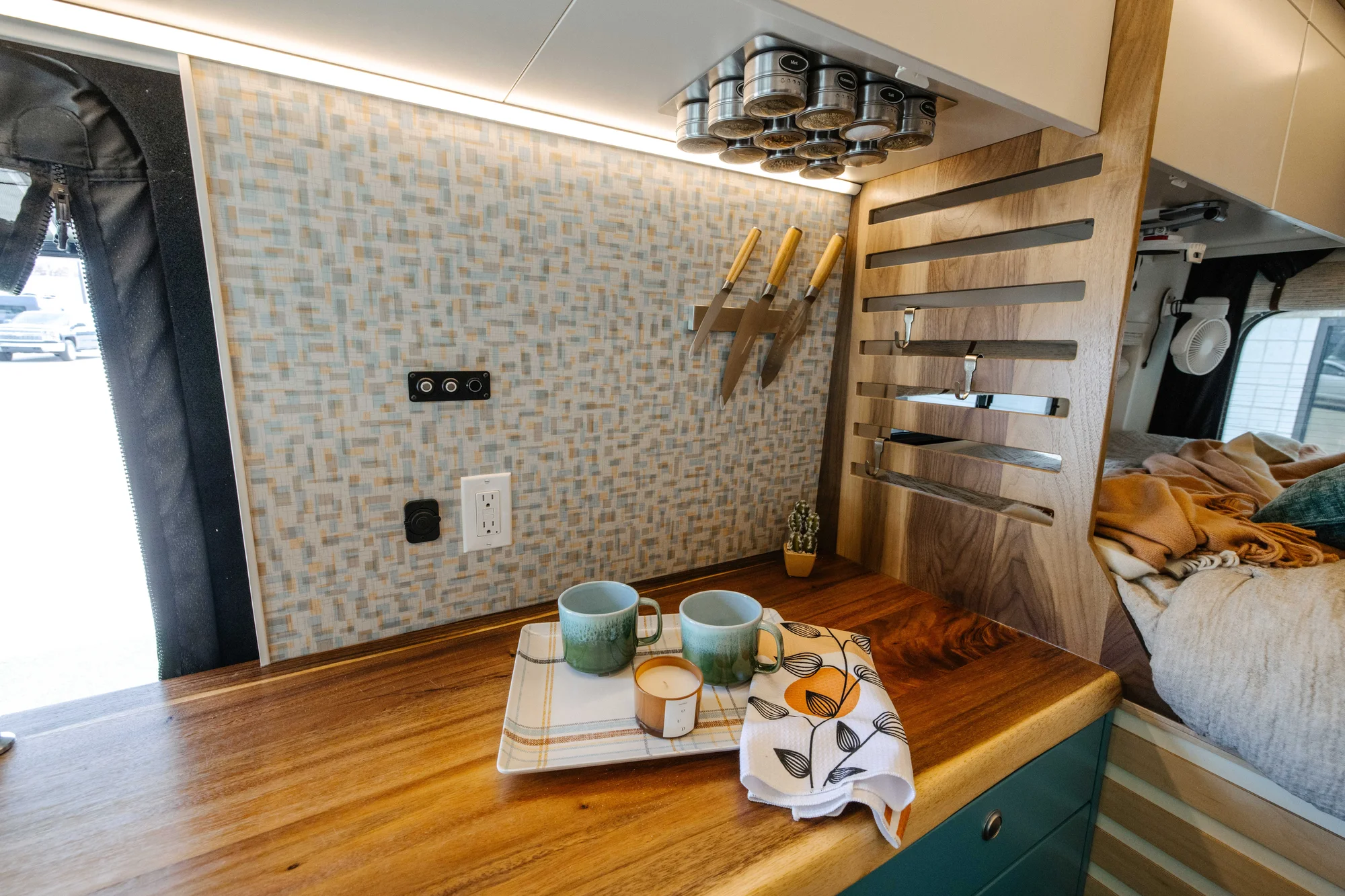 The Drifter 101 custom Ford Transit campervan built for Zach and Stephanie by Drifter Vans, with turquoise cabinetry, a custom wine rack, and Texas-inspired mid-century details